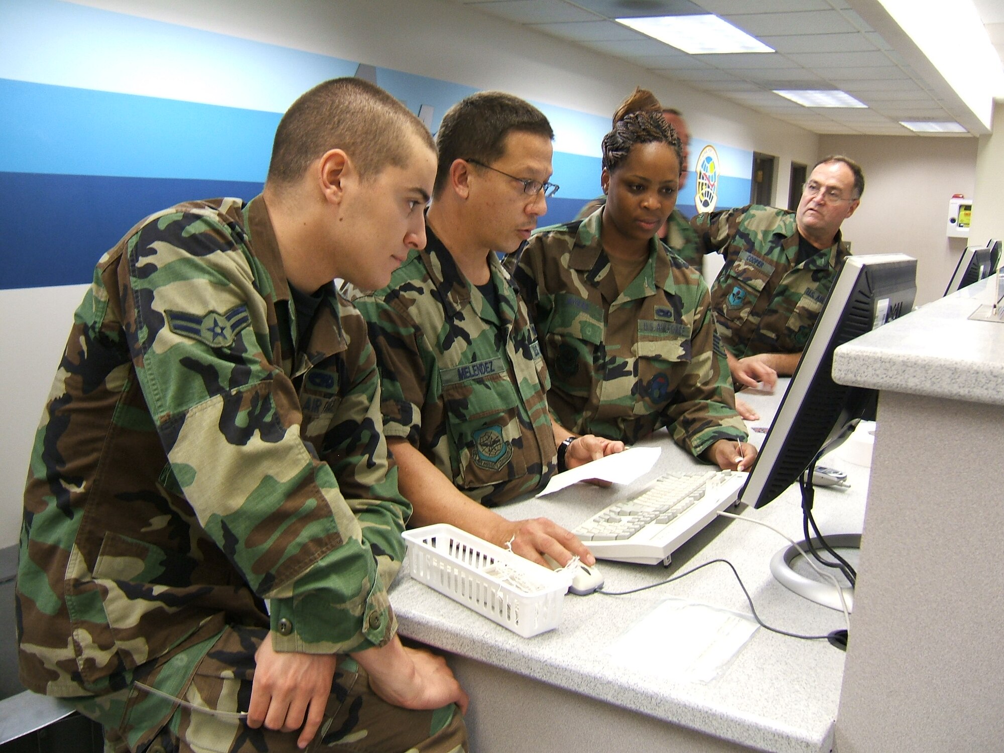 Staff Sgt. Jorge Melendez, second from left, of Homestead’s 70th Aerial Port Squadron provides training to other Airmen working in Passenger Services at Charleston Air Force Base, S.C. during Patriot Partner 2006. Reservists from the 70th APS led five other Reserve units in a partial takeover of port operations at Charleston (Air Force photo by Master Sgt. Roberta Milanowski)