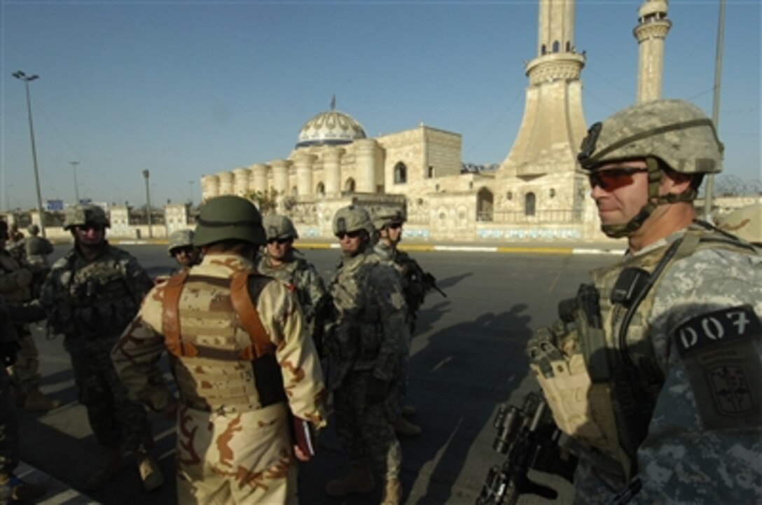 U.S. Army 1st Sgt. Dan L. Schoemaker helps secure the street outside of a mosque in the Ad Hamyah district of Baghdad, Iraq, so Iraqi army soldiers from the 9th Iraqi army can search it for ammunition caches on Sept. 2, 2006.  Schoemaker is assigned to Charlie Company, 1st Battalion, 17th Infantry Regiment, 172nd Stryker Brigade Combat Team.  