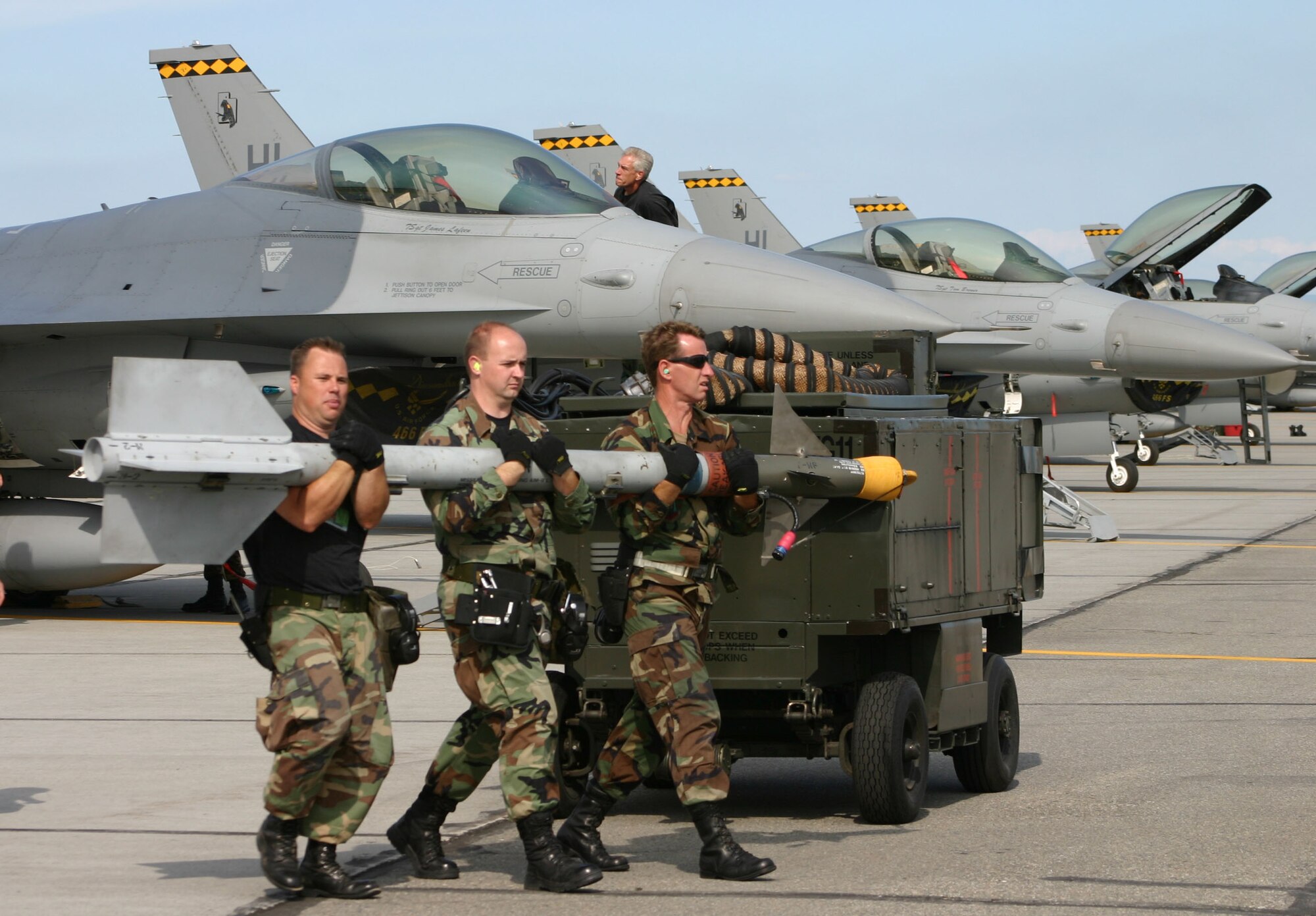 Members of the 419th Weapons Flight carry munitions to be loaded on a 419th FW F-16 during Cooperative Cope Thunder in Eielson, Alaska. Left to right: Tech. Sgt. Richard Blankenship, Senior Airman Alan Burton, Tech. Sgt. Joel Gurr.(U.S. Air Force Photo/Staff Sgt. Michael Owens)