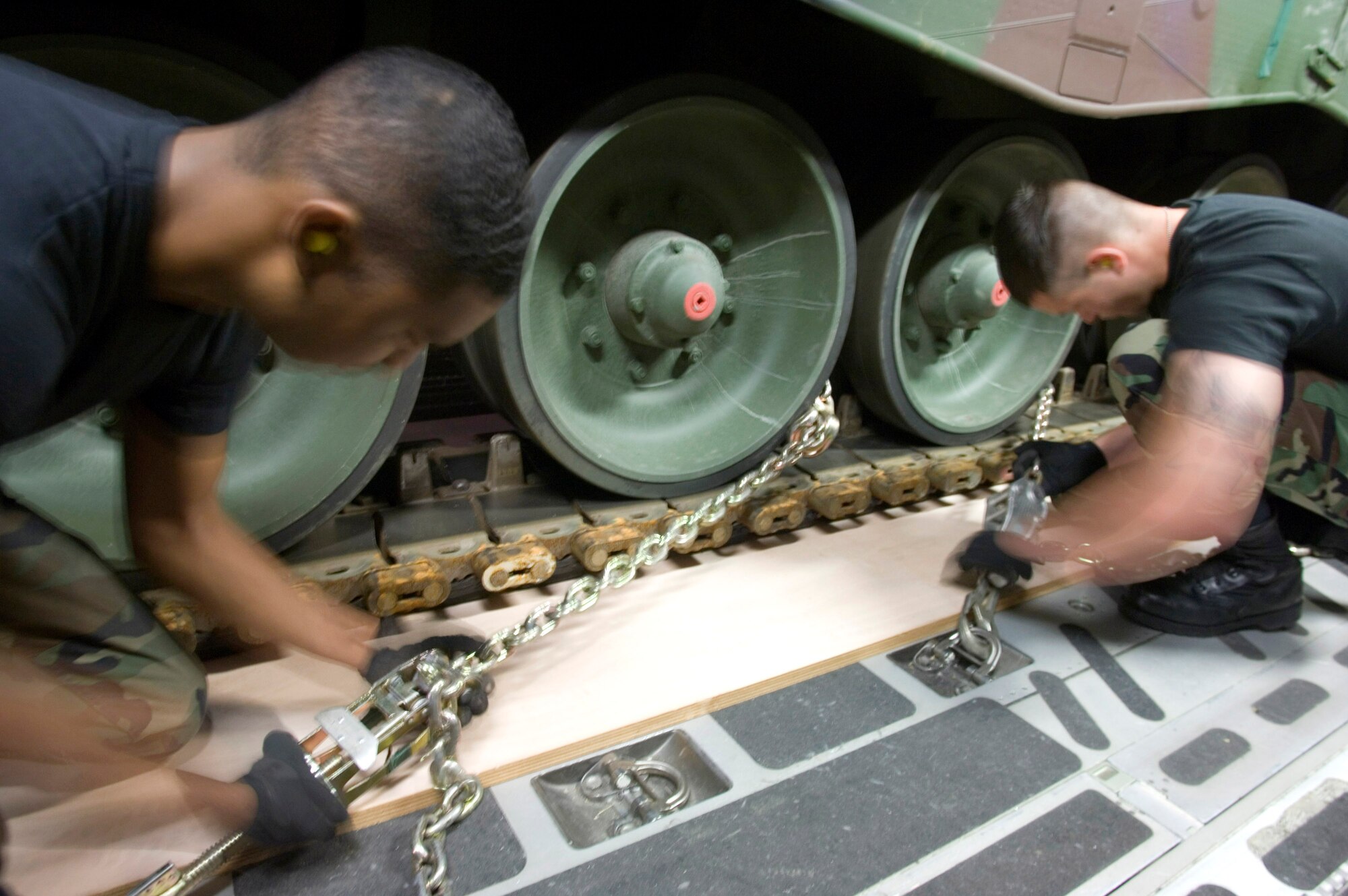 Airmen Jason Estell (left) and Andrey Benchea secure a Netherlander Howitzer 2000 on a C-17 Globemaster III at Ramstein Air Base, Germany, Sept. 6. The Airmen are air transportation specialists with Ramstein's 723rd Air Mobility Squadron working on the heavy air transport ensuring the 60-ton tank arrives safely in Afghanistan. (U.S. Air Force photo/Master Sgt. John Lasky)