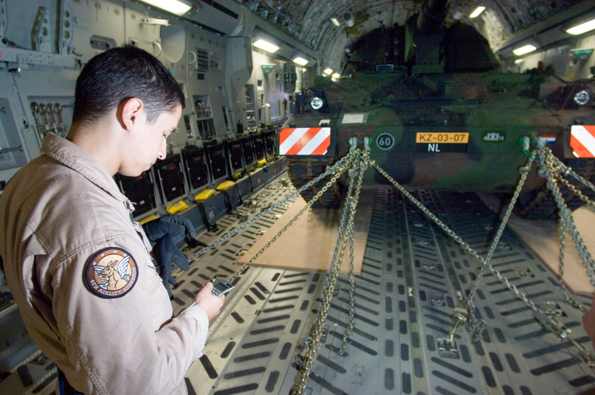 Airman 1st Class Joseph Ruiz calculates flight performance with a Netherlander Howitzer 2000 fastened to the floor of a C-17 Globemaster III at Ramstein Air Base, Germany, Sept. 6. Airman Ruiz is a loadmaster with the 4th Airlift Squadron at McChord Air Force Base, Wash. (U.S. Air Force photo/Master Sgt. John Lasky)