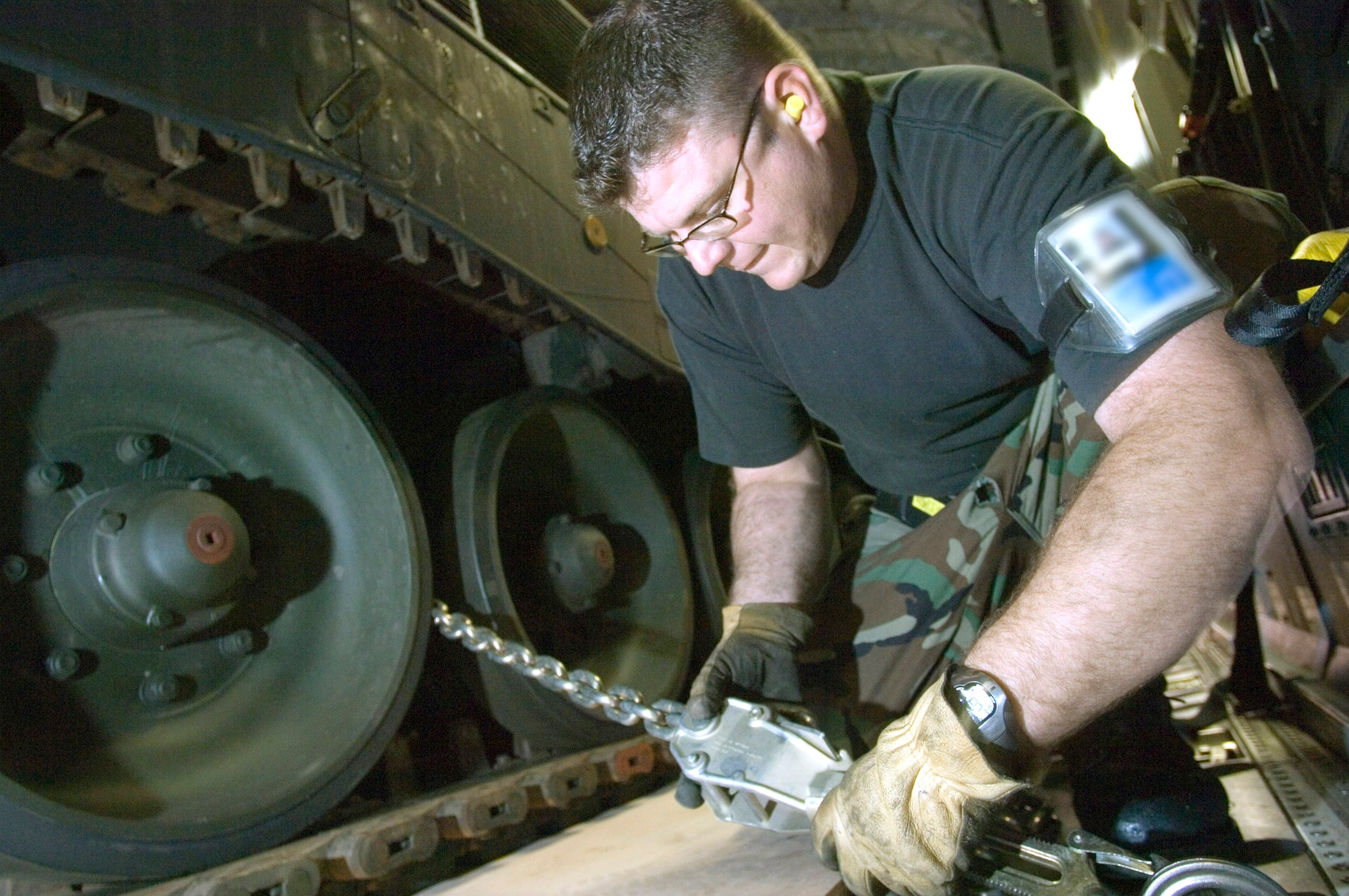Staff Sgt. Harold Gray fastens one of 29 chains to the floor securing the Netherlander Howitzer 2000 on a C-17 Globemaster III at Ramstein Air Base, Germany, Sept. 6. Sergeant Gray is an air transportation journeyman with Ramstein's 723rd Air Mobility Squadron. The 60-ton tank will be flown to Afghanistan on board a C-17 from Charleston Air Force Base, S.C. (U.S. Air Force photo/Master Sgt. John Lasky)