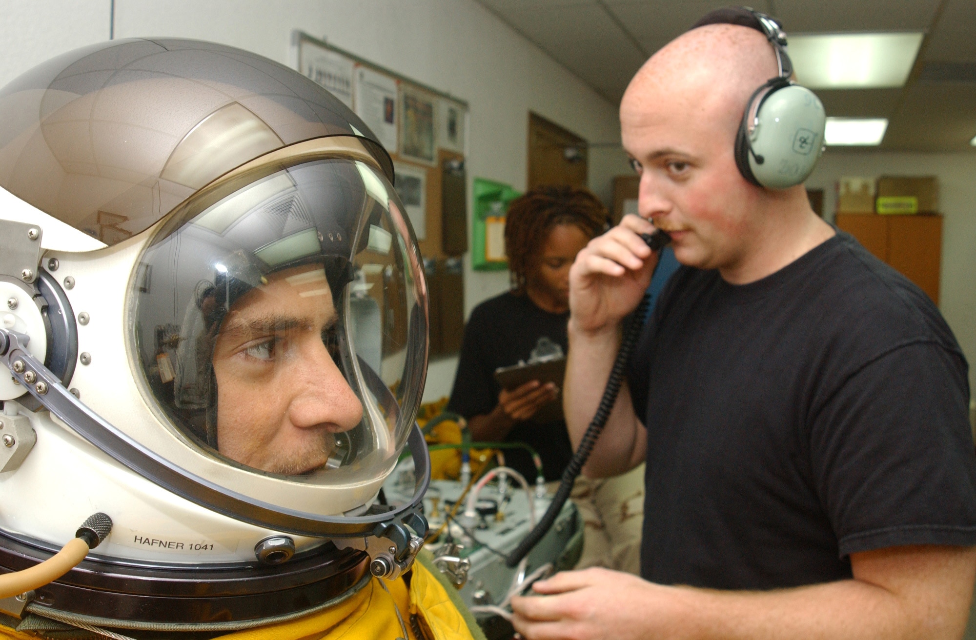 Capt. Greg Hafner listens as Senior Airman Shawn Nyer begins pressurization of his flight suit while Senior Airman Nakia Newton works in the background. The captain breathed nearly pure oxygen for almost 35 minutes before taking off on a U-2 mission. Captain Hafner is a U-2 pilot and Airman Nyer is a physiological support specialist assigned to the 99th Expeditionary Reconnaissance Squadron. (U.S. Air Force photo/Master Sgt. Jason Tudor)