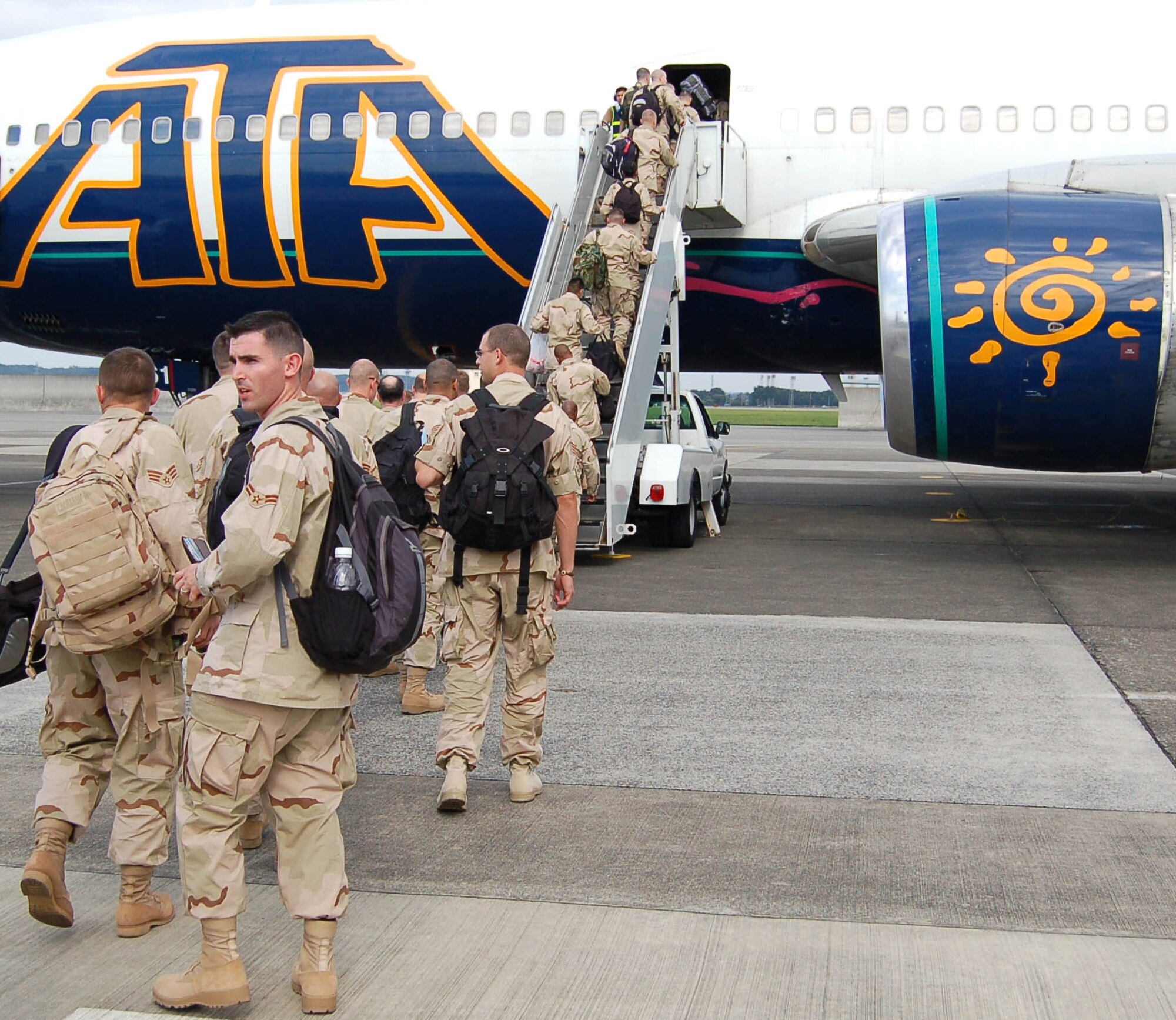 Airmen from the 374th Airlift Wing board their flight to depart Yokota Air Base, Japan. They are deploying for 120 days to support Operations Enduring Freedom and Iraqi Freedom. More than 300 Airmen from the base will support operations for Air Expeditionary Force 3 and 4. (U.S. Air Force photo/Capt. Warren Comer) 
