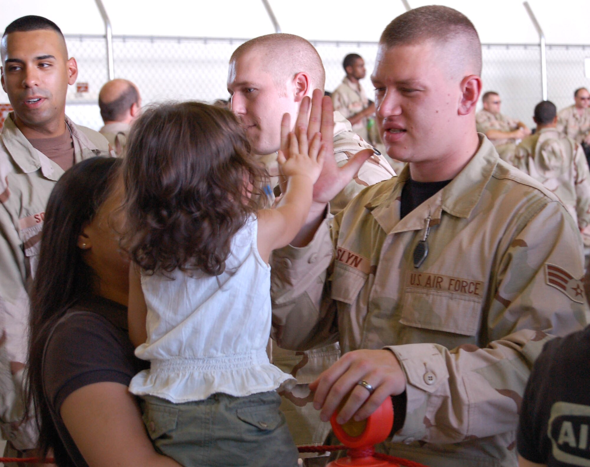 Senior Airman Joshua Joslyn gives a high five to his daughter before deploying in September. Approximately 70 Airmen from Yokota Air Base, Japan, deployed to support Operations Enduring Freedom and Iraqi Freedom. More than 300 Airmen are set to deploy from the base for Air Expeditionary Force 3 and 4. Airman Joslyn is assigned to the 374th Logisitics Readiness Squadron. (U.S. Air Force photo/Capt. Warren Comer) 
