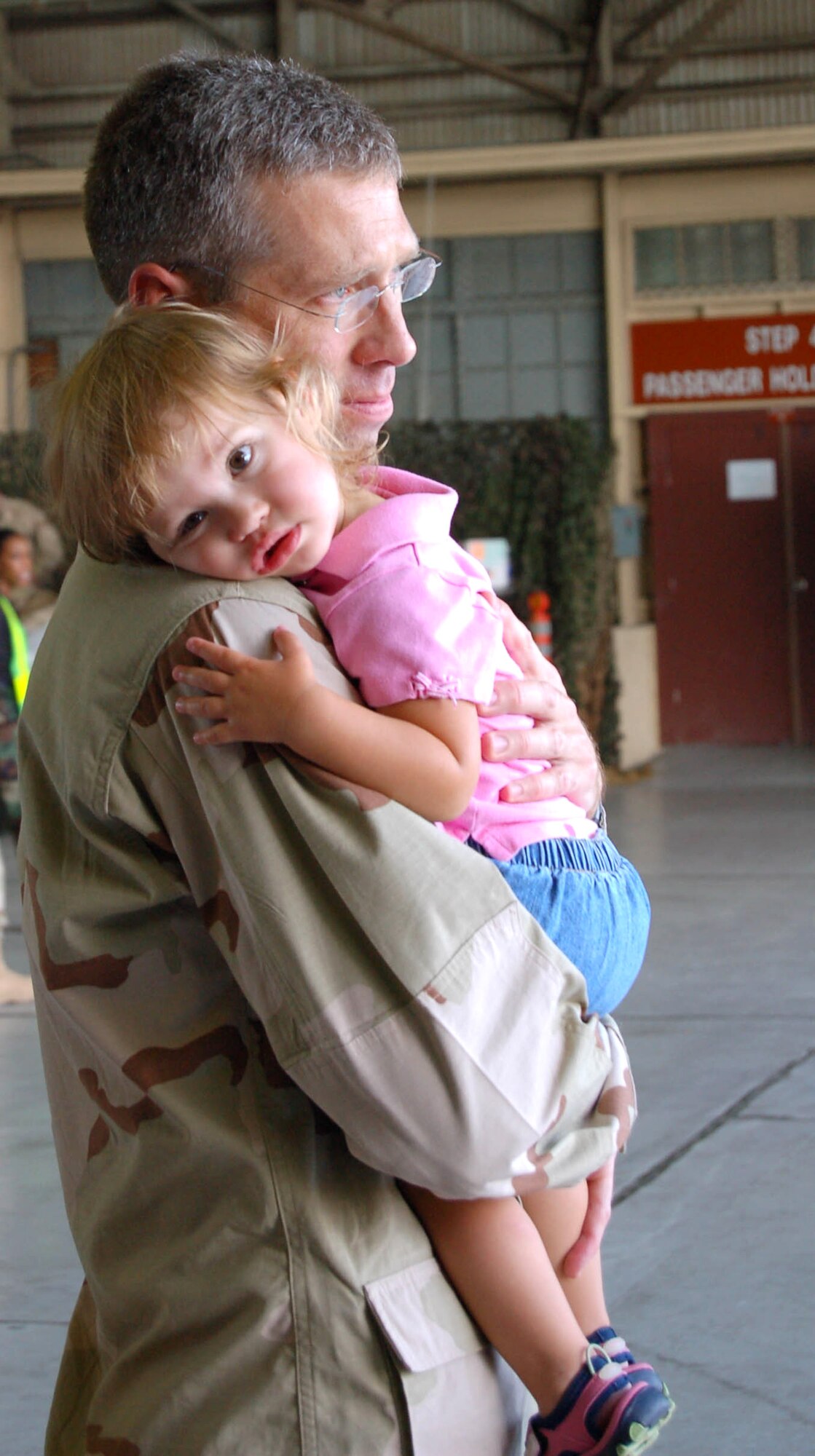 Lt. Col. Douglas Dickerson hugs his daughter one last time before deploying in September. Approximately 70 Airmen from Yokota Air Base, Japan, deployed in support of Operations Enduring Freedom and Iraqi Freedom; more than 300 Airmen from Yokota are set to deploy during Air Expeditionary Force 3 and 4. Colonel Dickerson is the 374th Logistics Readiness Squadron director of operations. (U.S. Air Force photo/Capt. Warren Comer)
