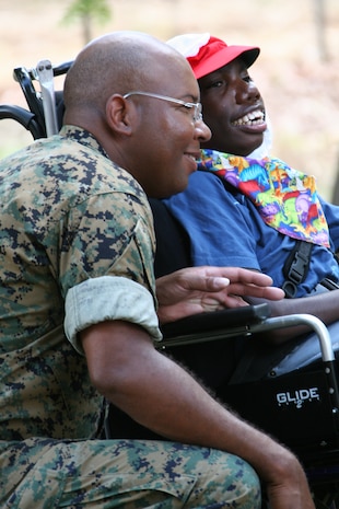 Petty Officer 1st Class, Alverez M. Hemphill, Marine Aircraft Group 12 religious program specialist, takes time to pose with Jesiah Jerry, a 16-year-old student at the Kintore Street School, for a local Katherine Times reporter covering the event. Together the Rock Hill, S.C. native and the MAG-12 chaplain are planning two additional community relations events for the Marines and sailors while deployed to Australia.