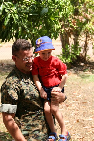 Cpl. Karl A. Schweiger, VMFA-212 F/A-18 plane captain, makes friends with Liam C. Smith, a student at South Katherine Preschool. Lt. Cmdr. Brent D. Johnson, Marine Aircraft Group 12 chaplain, accepted a plaque, pictures and a flag on behalf of the Marines who volunteered to work at the Kintore Street School during last year?s Exercise Southern Frontier.