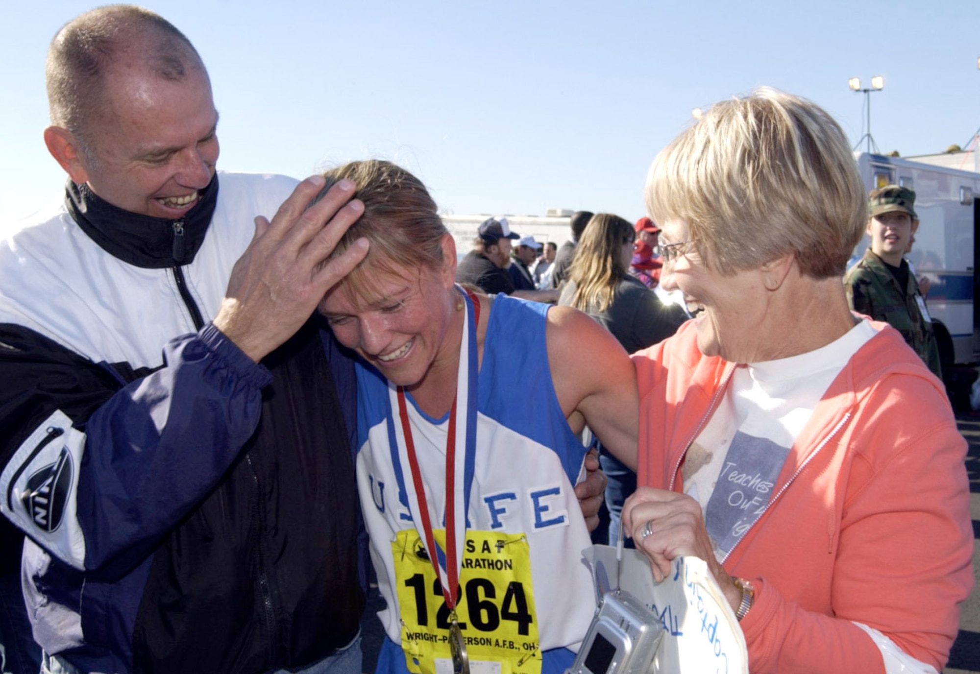 Maj. Jill Metzger, the personnel chief at the 376th Air Expeditionary Wing at Manas Air Base, Kyrgyzstan is still missing after disappearing during a trip to a shopping center in the nearby capital city of Bishkek.  Major Metzger, a champion marathon runner, is shown here being congratulated by her parents, John and Jeannette, after crossing the line as the first female finisher of the 2004 Air Force Marathon.  (U.S. Air Force photo/Spencer Lane)