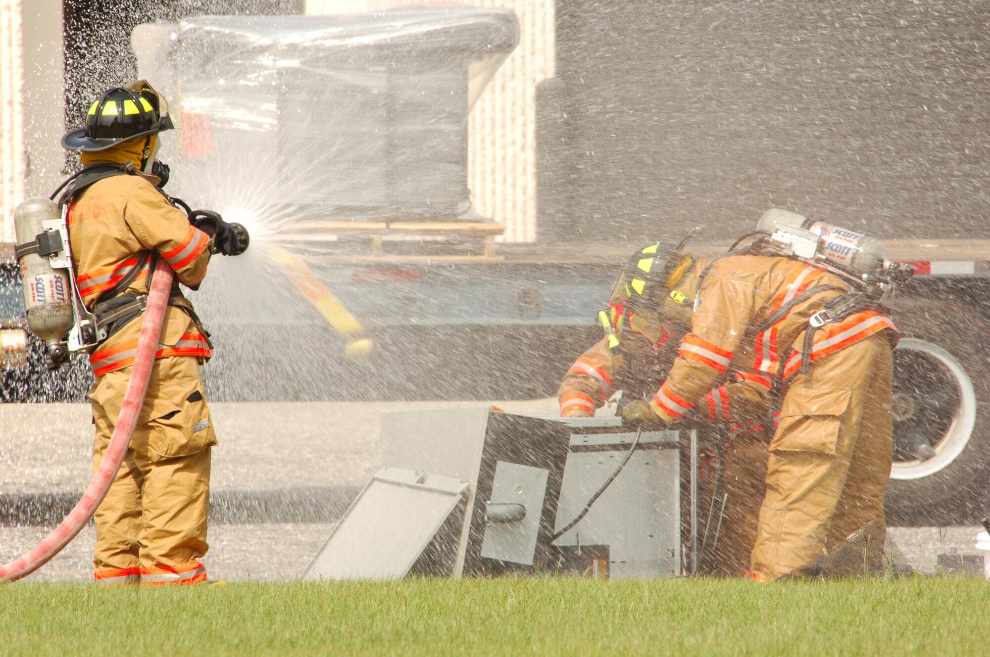 SHAW AIR FORCE BASE, S.C.-- Airman Mark Molnar (left) and other 20th Civil Engineer Squadron Fire Department members respond to Bldg. 1052 Tuesday after a pallet of batteries fell from a commercial vehicle. The Airmen used non-sparking tools to disconnect the batteries and water to prevent fumes and neutralize any acid. (U.S. Air Force photo/Airman 1st Class Kathrine Dodd)