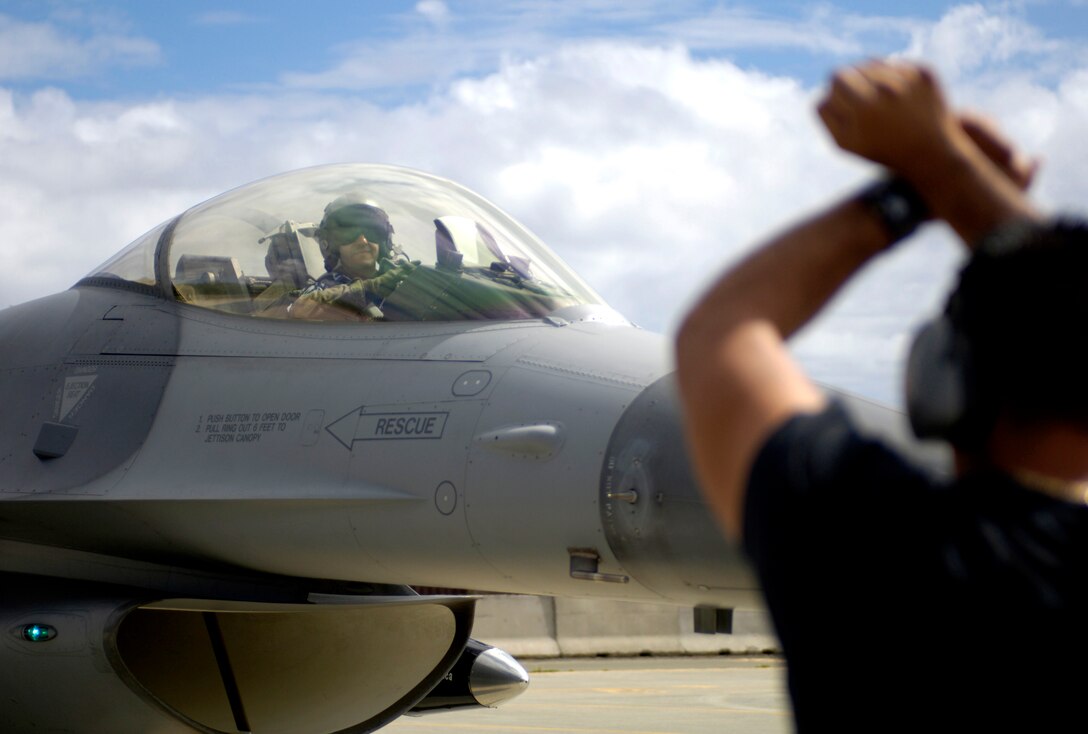 Master Sgt. Carlos Rodriguez marshals an F-16 Fighting Falcon to its parking spot  at Hickam Air Force Base, Hawaii, Sept. 6. Six F-16s and crews from the Texas Air National Guard's 149th Fighter Wing are participating in Exercise Sentry Aloha. The exercise brings dissimilar combat assets to Hickam to train with the Hawaii Air National Guard's 199th Fighter Squadron. (U.S. Air Force photo/Tech. Sgt. Shane A. Cuomo) 
