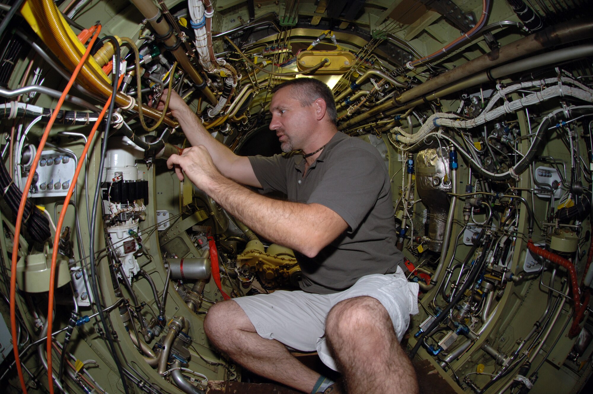 Jay Gardner, one of 19 Lockheed employees assigned to a forward-operating base in Southwest Asia, inspects hydraulic tubing in a U-2 fuselage. A U-2 receives a phase inspection every 400 hours. (U.S. Air Force photo/Staff Sgt. Alicia Flores)