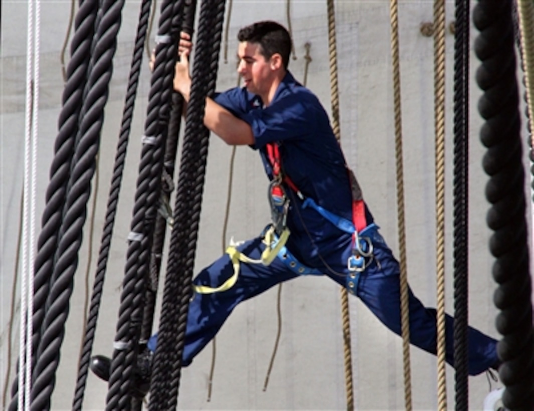 U.S. Navy Petty Officer 3rd Class Oran Feiner moves among the main shrouds during the Chief Petty Officer turnaround cruise aboard the USS Constitution in Boston Harbor, Sept. 1, 2006. Each year, Constitution hosts approximately 300 selectees for training, which includes sail handling, gun drill training and community outreach designed to enhance leadership and teamwork skills. 

