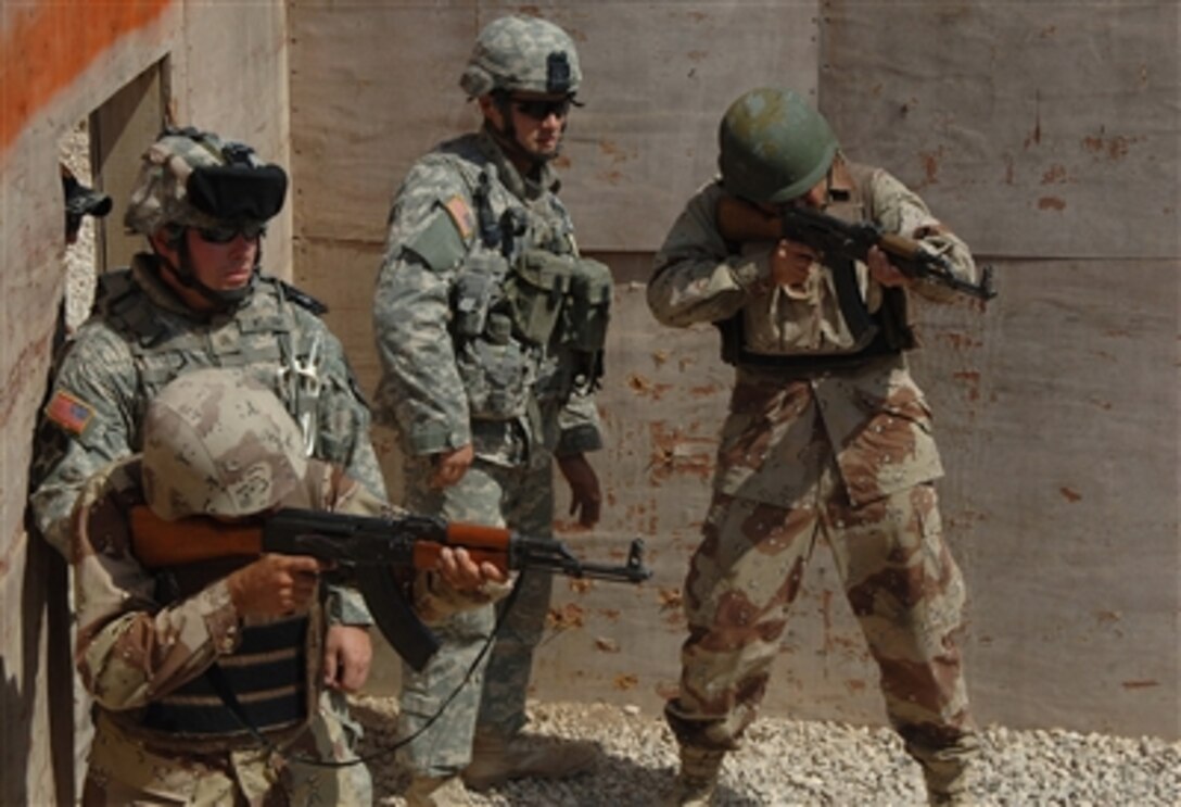 U.S. Army soldiers from the 5th Battalion, 20th Infantry Regiment watch as Iraqi army soldiers engage targets at a range during a weeklong advanced training course in Mosul, Iraq, on Sept. 1, 2006.  