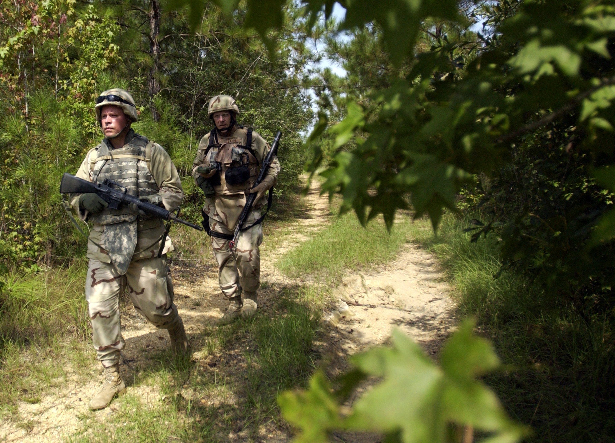 Capt. Michael Schroeder (front) and Tech. Sgt. Gene Lappe search for a land navigation point and improvised explosive devices Aug. 30 using techniques learned at Camp Shelby, Miss.  Camp Shelby is one of several Army installations providing training to military personnel preparing to deploy to Southwest Asia.  (U.S. Air Force photo/Tech. Sgt. Cecilio Ricardo Jr.)

