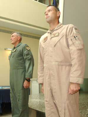 MINOT AIR FORCE BASE, N.D. -- Maj. Douglas Webb (far right), 5th  Medical Operations Squadron, stands at attention next to Col. Eldon Woodie, 5th Bomb Wing commander, before being presented the Bronze Star award during a ceremony at the 5th Medical Group building, Aug. 30. (U.S. Air Force photo by Airman Sharida Bishop)