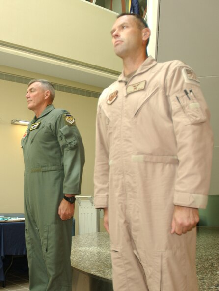 MINOT AIR FORCE BASE, N.D. -- Maj. Douglas Webb (far right), 5th  Medical Operations Squadron, stands at attention next to Col. Eldon Woodie, 5th Bomb Wing commander, before being presented the Bronze Star award during a ceremony at the 5th Medical Group building, Aug. 30. (U.S. Air Force photo by Airman Sharida Bishop)