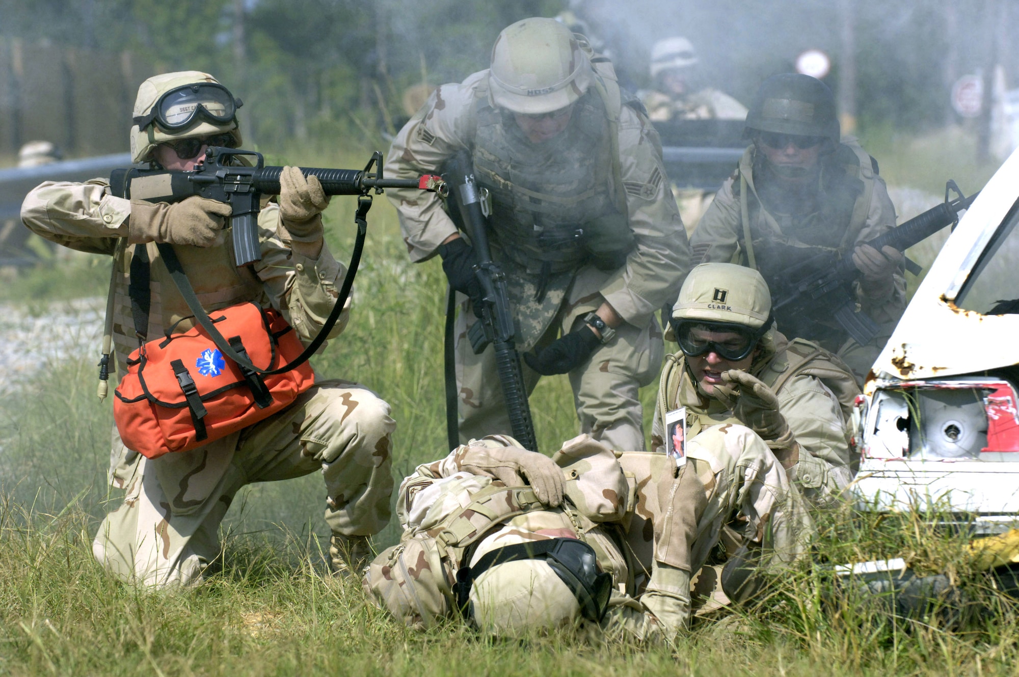 After simulated sniper fire "wounded" Tech. Sgt. Chris Vadnais during training at Camp Shelby, Miss., Capt. John Clark and Senior Airman Jeremy Hofstetter tend to him as Staff Sgt. Ian Carrier returns fire. The exercise was part of a combat skills course preparing Airmen to deploy to Southwest Asia. (U.S. Air Force photo/Master Sgt. Scott Wagers)

