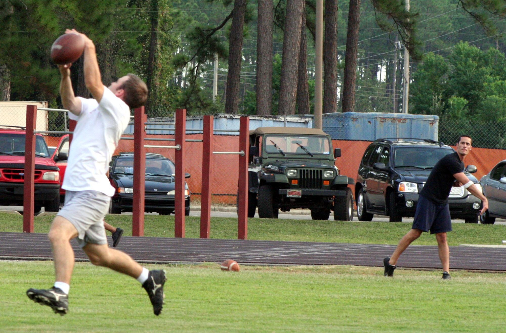 Terrell Tillery, 16th Mission Support Squadron, passes to Chris Barlett, 16th MSS, during a men's flag football practice Sept. 5 at the Aderholt Fitness Center. The men's flag football season begins Sept. 11 and the women's begins Sept. 19. (U.S. Air Force Photograph by Staff Sgt. Mareshah Haynes)

