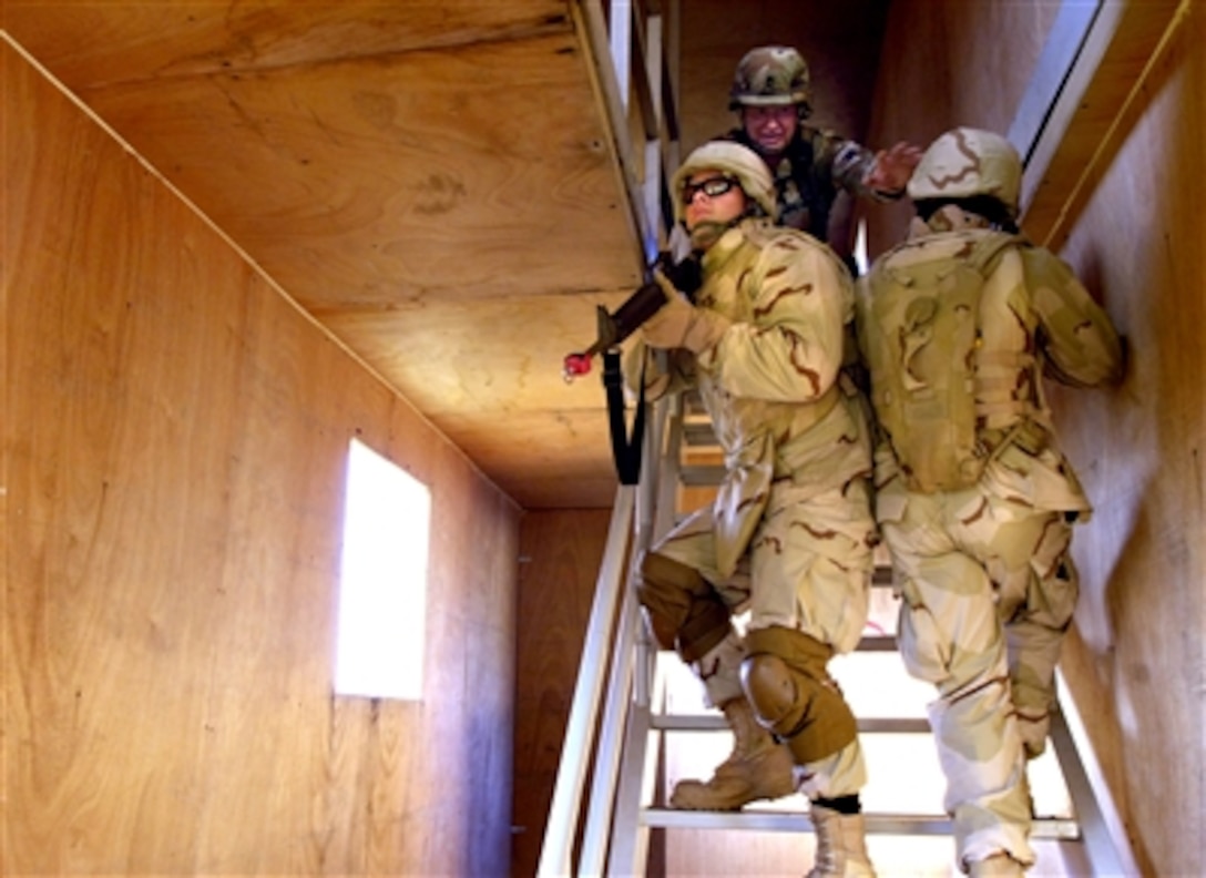 U.S. Army Sgt. 1st Class Daniel Criddle (top) instructs 1st Lt. Steven Maddox (left) and Staff Sgt. Travis Haywood on the importance of synchronizing movements when clearing a stairwell during a course on urban warfare at Camp Shelby, Miss., Sept. 2, 2006.  Camp Shelby is one of several Army installations providing training to military personnel preparing to deploy to Southwest Asia.  