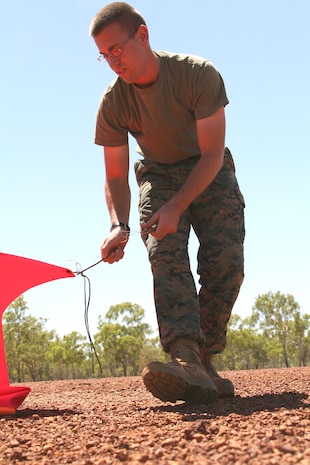 Lance Cpl. Ryan P. Chezick, a Marine Wing Support Squadron172 expeditionary airfield systems technician, collects day-marker panels along the airfield at the conclusion of the day's Assault Landing Zone training at the Delamere Range Facility for Exercise Southern Frontier, Sept. 8. Chezick's job, during the touch-and-go ALZ training,  is to spot the landings on the ground and radio the results back to the pilot so he can make adjustments.
