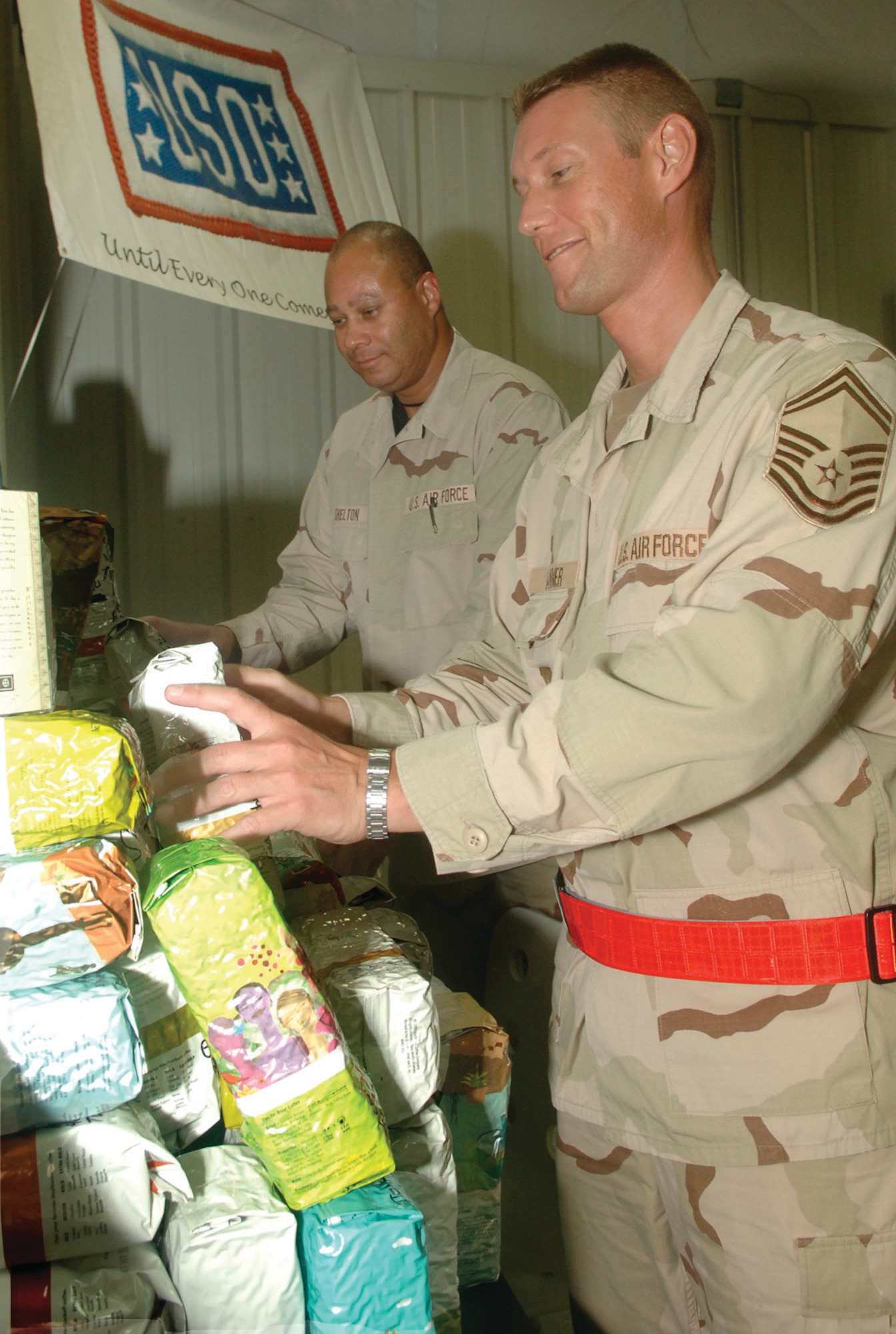 Master Sgt. Joel Shelton (left) and Senior Master Sgt. Scott Wanner, both 8th Expeditionary Air Mobility Squadron, stack donated Starbucks coffee in the new USO facility at the Mighty 8th passenger terminal Monday. Patrons of the famed coffee chain in Gig Harbor, Wash., purchased more than 8,000 pounds of coffee beans to donate to troops. (USAF photos by Senior Airman Melissa Padilla)