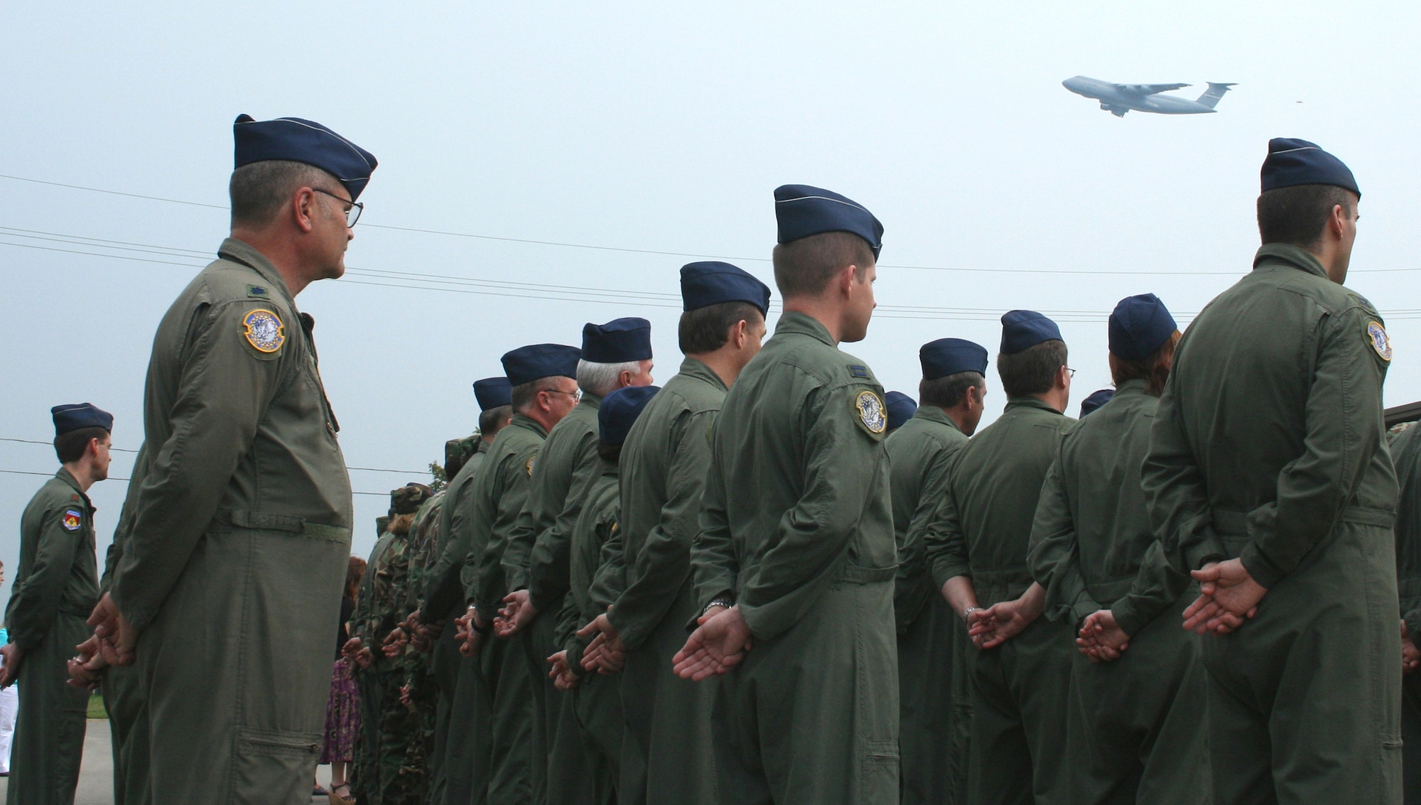 WRIGHT-PATTERSON AFB, Ohio -- A C-5 Galaxy aircraft passes by as members from the 445th Airlift Wing stand in formation during the their Patriot Day ceremony. (U.S. Air Force photo by Maj. Ted Theopolos).