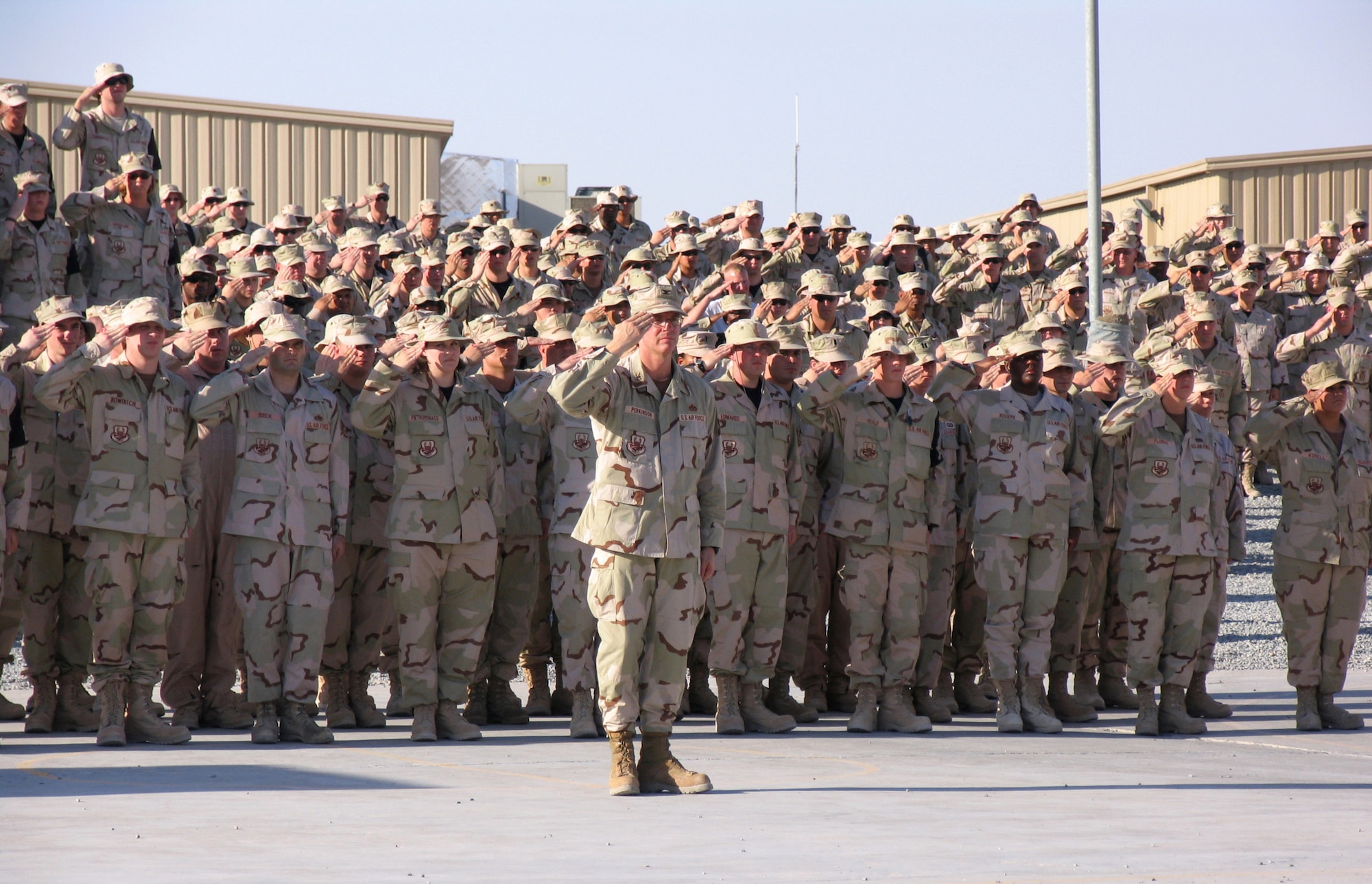 Col. Gregory Perkinson, 386th Expeditionary Mission Support Group commander, and Airmen of the 386th Air Expeditionary Wing salute during a 9/11 memorial service Sept. 11 in Southwest Asia. Coalition members from the Australia Defense Force, Japan Air Self Defense Force and Republic of Korea Air Forces also attended the event. (U.S. Air Force photo/Staff Sgt. Ryan Hansen)