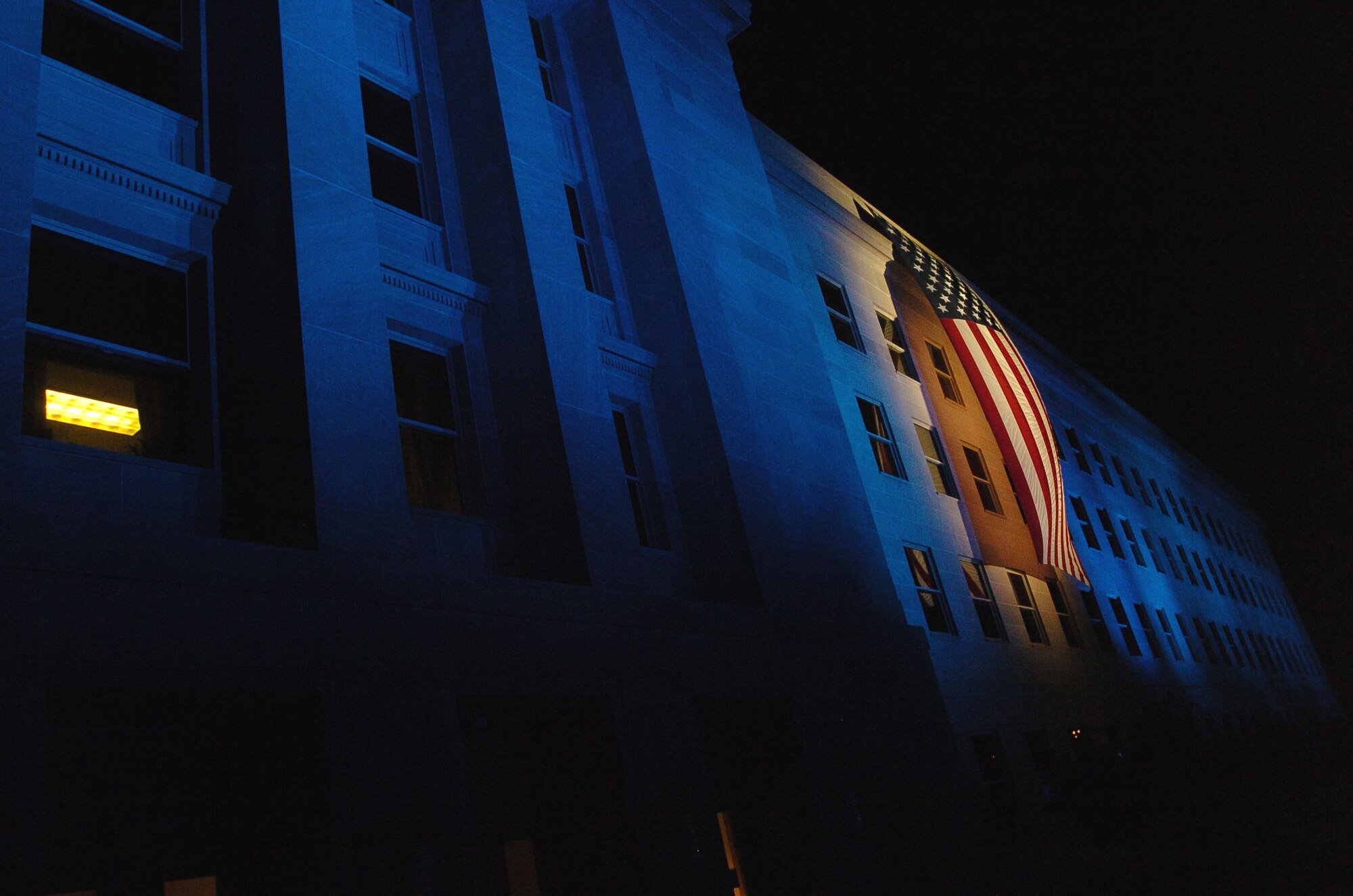 A flag hangs as a memorial during the 2nd Annual Freedom Walk at the Pentagon Sept. 10. The flag and lights illuminate the spot where American Airlines Flight 77 crashed into the Pentagon Sept. 11, 2001. As part of the tribute, 184 beams of light rose from the courtyard of the Pentagon for each of the lives lost when the plane crashed into the building. (DOD photo/Petty Officer 1st Class Chad J. McNeeley)
