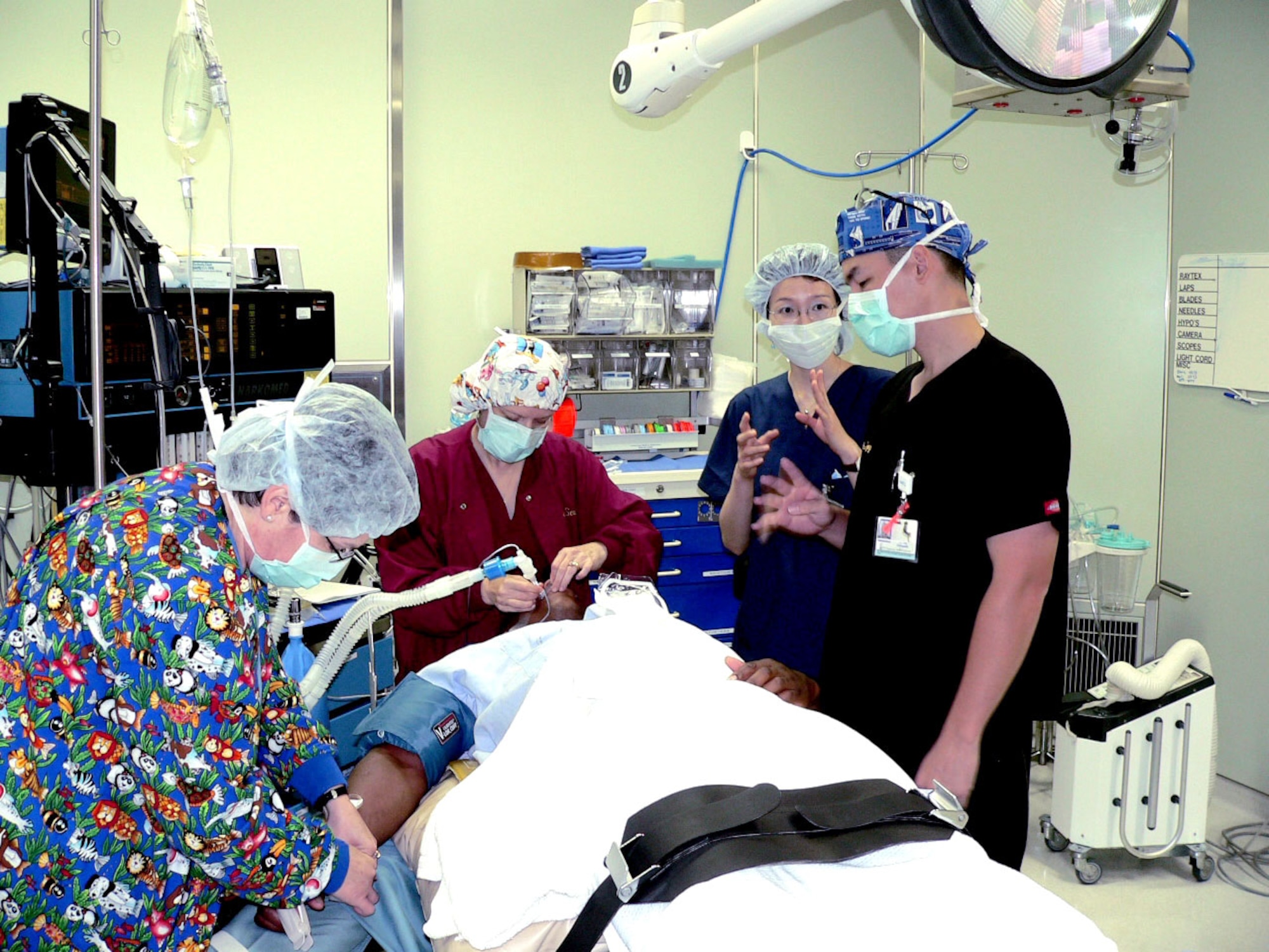 Chihiro Nakazawa, a fifth-year medical student at Hirosaki University School of Medicine in Aomori prefecture, asks questions while observing base medical staff prepare a patient for surgery at Misawa Air Base, Japan. (U.S. Air Force photo)
