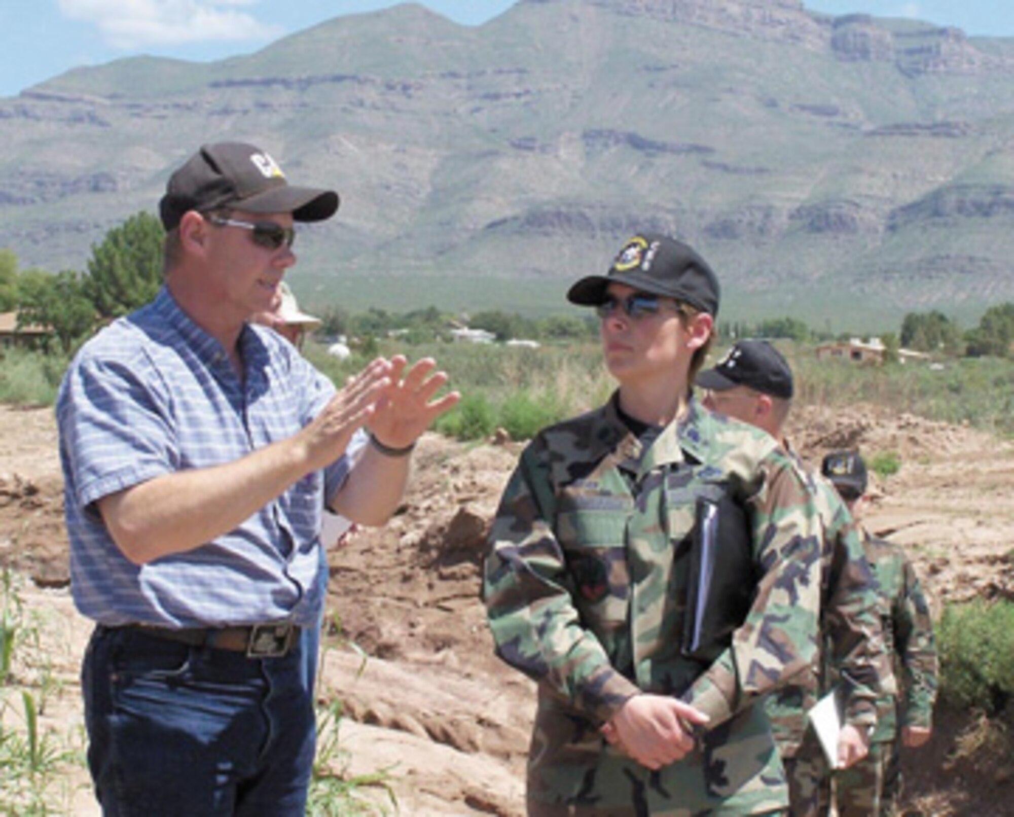 Otero County Public Works Director Bill Parker, left, talks with Lt. Col. Andra Clapsaddle, commander 49th Civil Engineer Squadron, as Airmen and county personnel begin clearing a section of land along the lower Alamo Canyon drainage channel.
