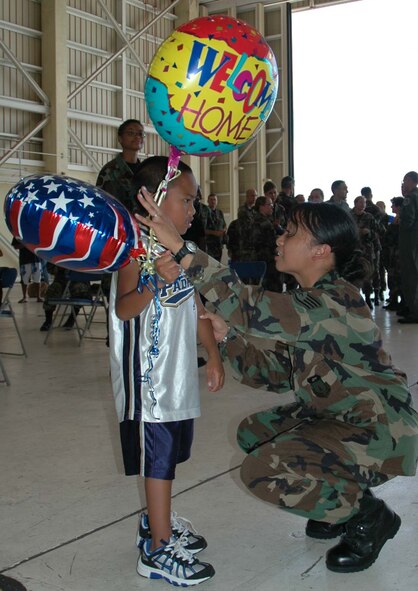 ANDERSEN AFB, Guam - Air Force Staff Sgt. Mary Anne Viloria, 36th Medical Group, shares a quiet moment with her son, R.J. Viloria, 7 during a celebration welcoming the members of the 36th Medical Group, from the 36th Wing and the U.S. Navy Helicopter Sea Combat Squadron 25, stationed at Andersen Air Force Base, Guam.  Sergeant Viloria returned to Andersen AFB, Guam following a 72-day deployment aboard the USNS Mercy where she participated in theater security cooperation and medical assistance missions in partnership with non-governmental organizations, international military medical personnel and host nations of the Philippines, Bangladesh, Indonesia and East Timor.    Photo by: Senior Airman Angelique Smyth, 36th Wing Public Affairs.