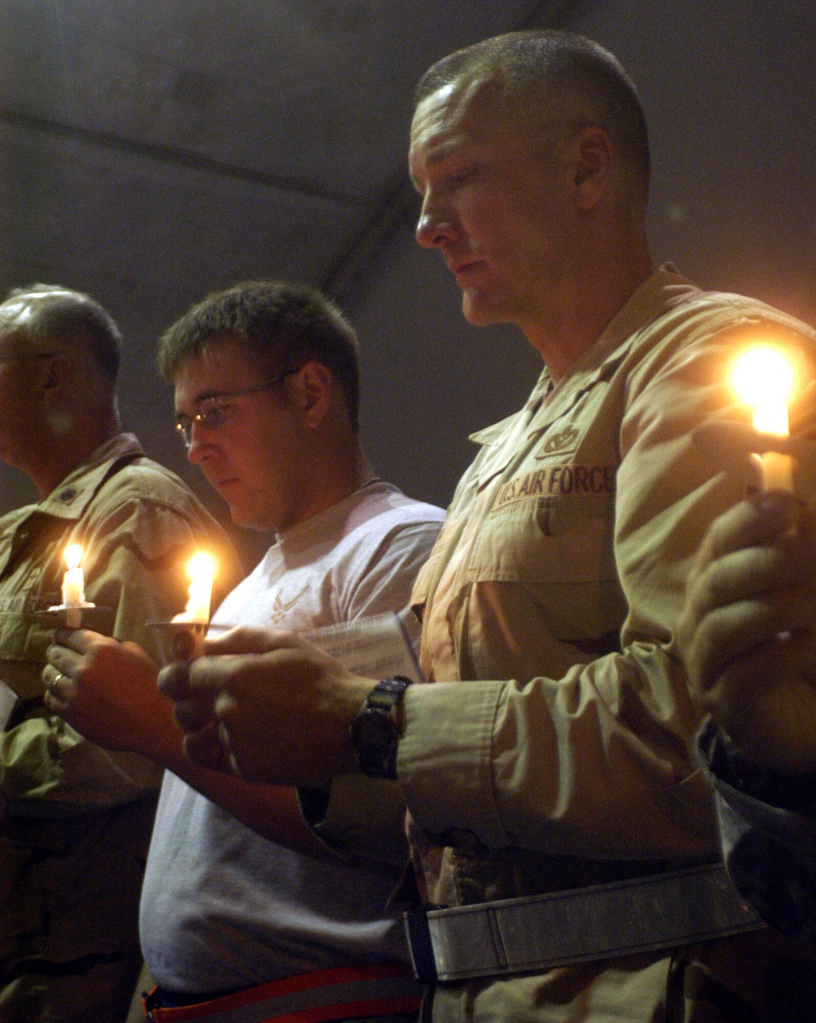 Chief Master Sergeant Mark Brejcha, 755th Expeditionary Mission Support Group superintendent and Senior Airmen Reese Vaughan, Bagram PRT member, stand in silence during the 9/11 Candlelight Service at Bagram Airfield, Afghanistan. More than 100 deployed members remembered the lives of those lost in a terrorist attack planned not far from where Airmen in the 455th Air Expeditionary Wing are deployed for Operation Enduring Freedom.  (U.S. Air Force photo/Capt Vince King Jr.)                          