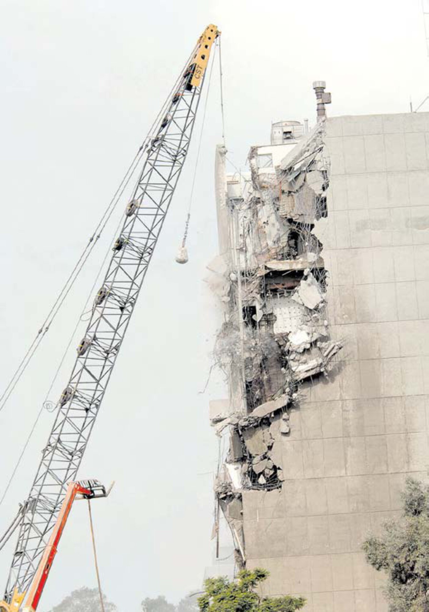 Large chunks of concrete fall off as the wrecking ball takes another swing at Building 105, the former Space and Missile Systems Center's main building in Area A. Other structures have been systematically demolished by a private crew to make way for a residential neighborhood. The process is in accordance with the Systems Acquisition Management Support Complex project.