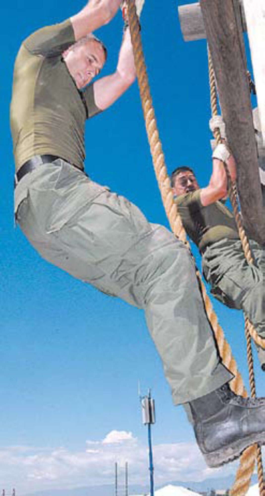 (Left to right) Capt. Jonathan Baker and Cpl. Manuel Rodriguez scale down ropes of the tough-man station during the obstacle course.