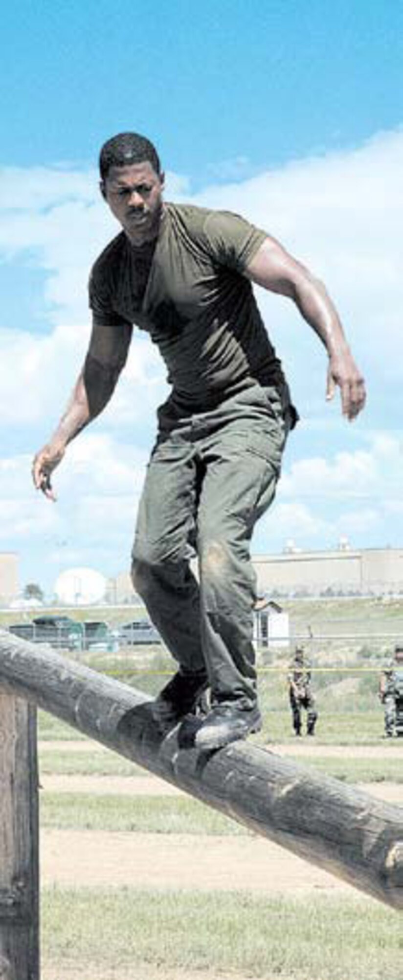Capt. (DoD Police) Scott Hall balances himself as he walks across the pole at one of the obstacle course stations.
