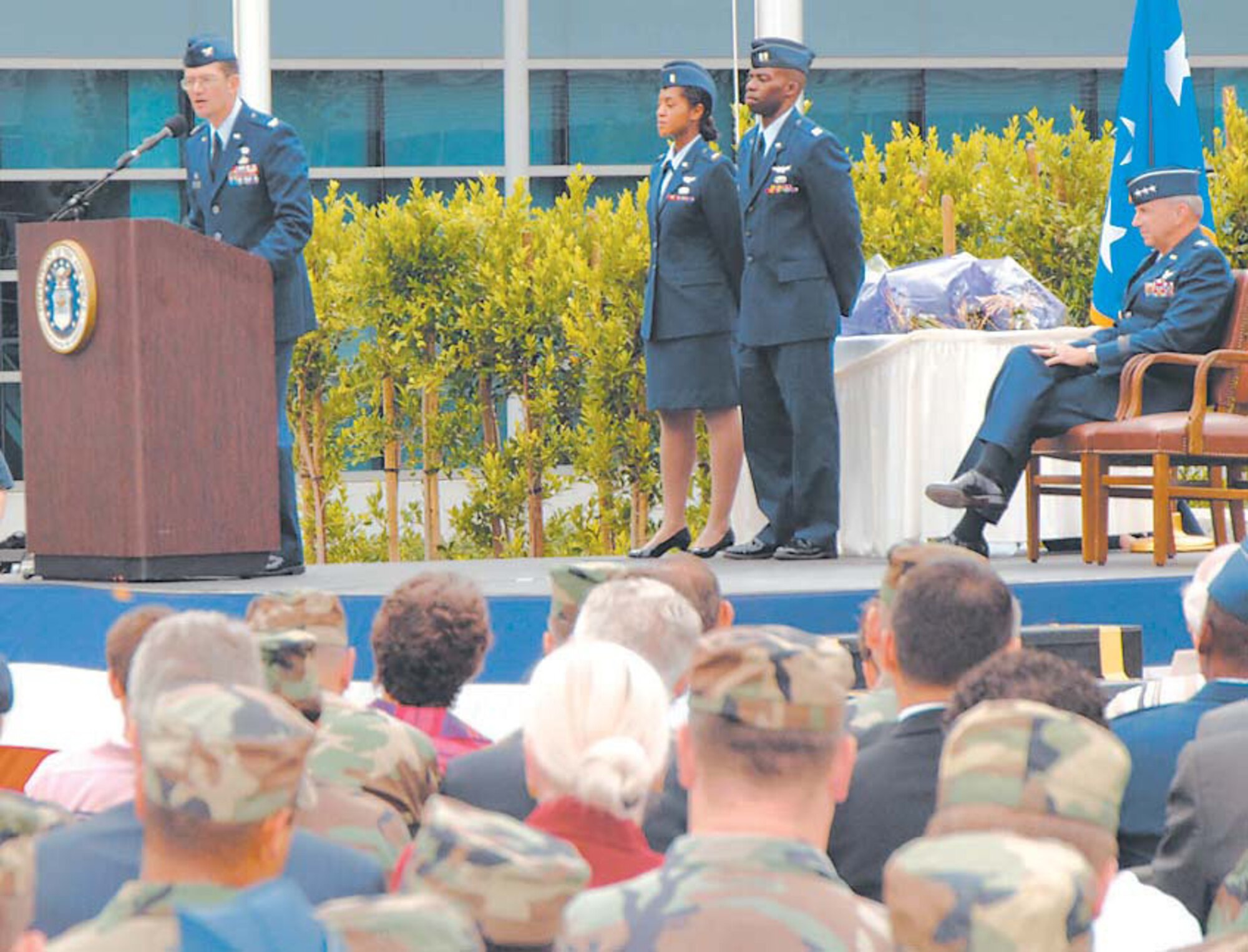 Col. Joe Schwarz, 61st Air Base Wing commander addresses the crowd during the SMC Wing standup. Lt. Gen. Michael Hamel, SMC commander (seated right), headed the historical ceremony at the Schriever Space Complex, July 31.