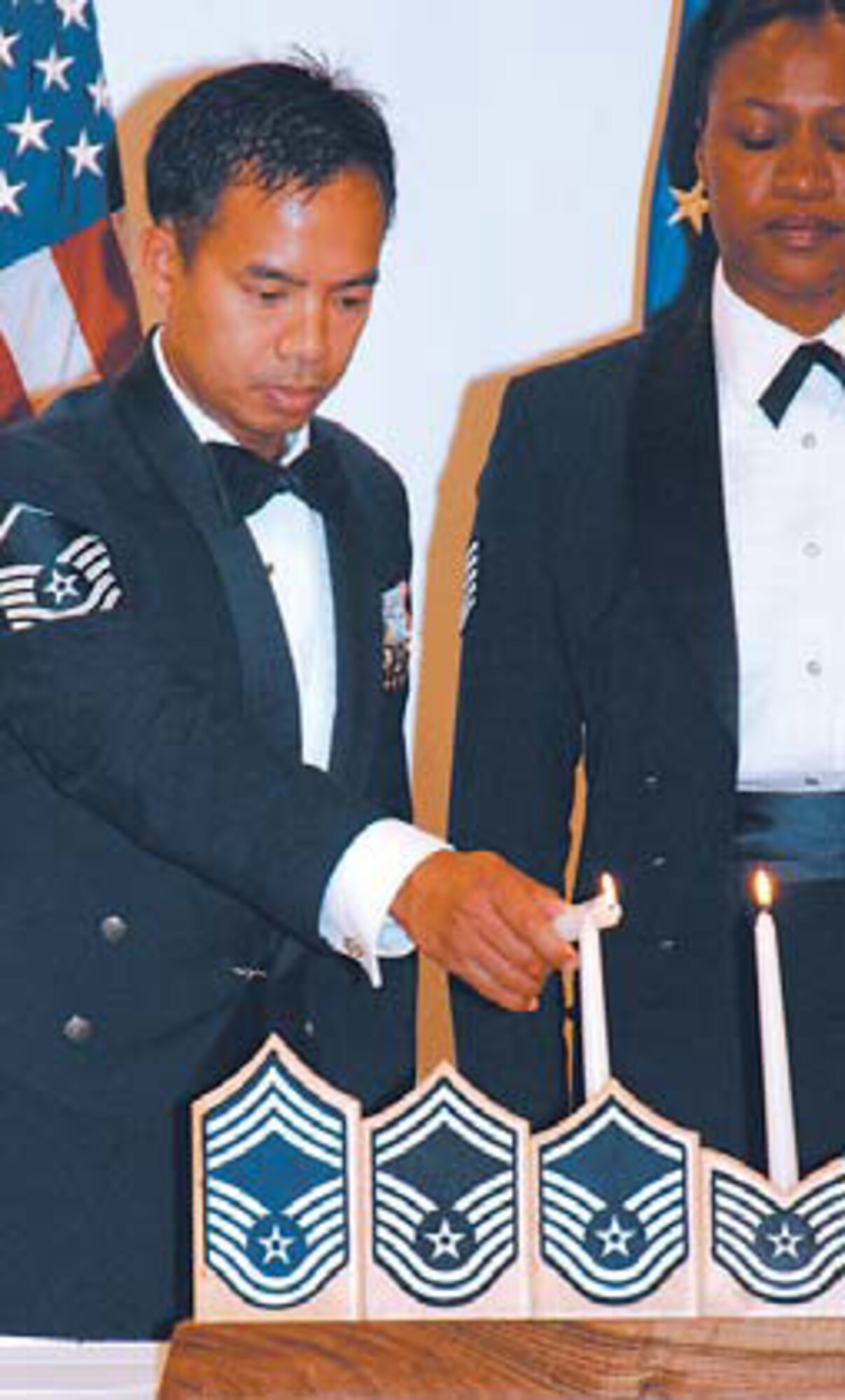 Master Sgt. Narciso Abutin, lights the Candelabra representing the nine enlisted grades of the Air Force.