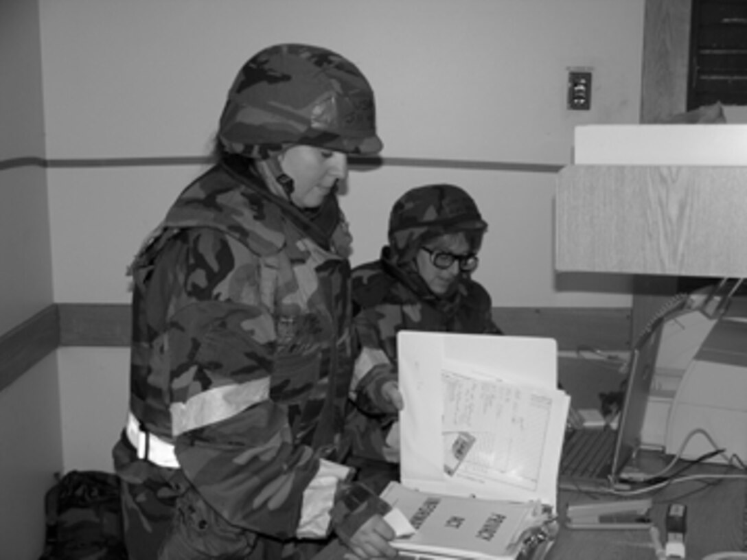 Master Sgt. Jill Weissflog checks over her classified information while another member of the 612th Air Expeditionary Wing looks on. Sergeant Weissflog is a chief of personnel employment with the 916th Mission Support Flight.