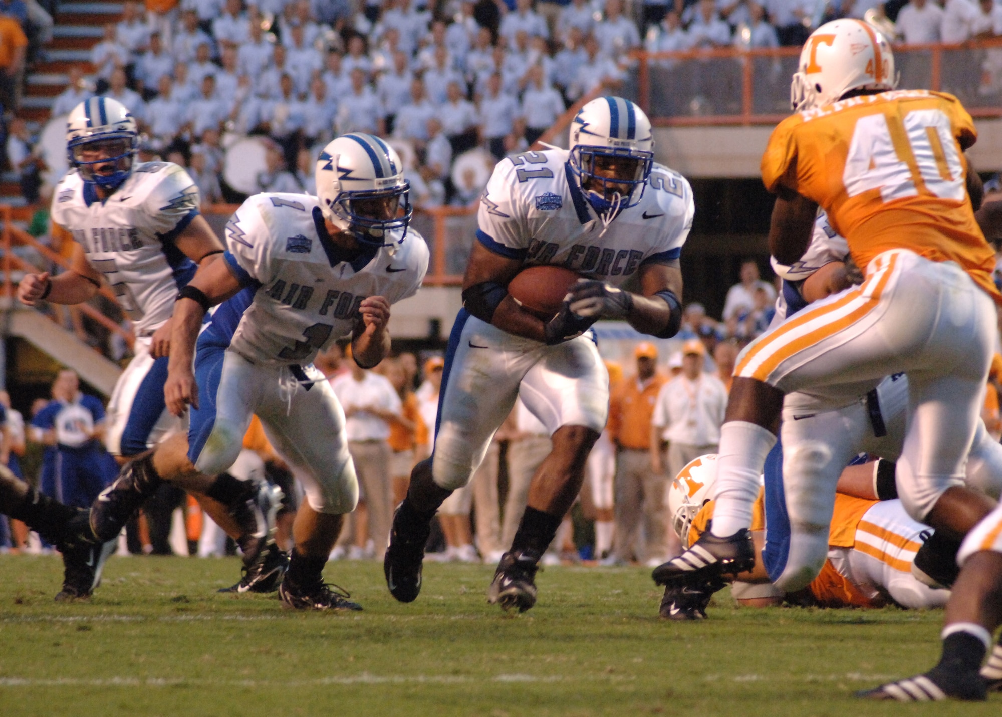 Air Force Academy Falcons fullback Ryan Williams (21) prepares do deliver a mid-field blow to Tennessee middle linebacker Marvin Mitchell.  Williams' 98 rushing yards led the Falcons' ground game, which ended the game with 51 carries for 281 yards.  In a very tight game Sept. 9, the Falcons' clock-eating triple-option offense nearly pulled off an upset over #11 Tennessee, which managed to hold off the Falcons for a 31-30 victory. (U.S. Air Force photo/John Van Winkle)