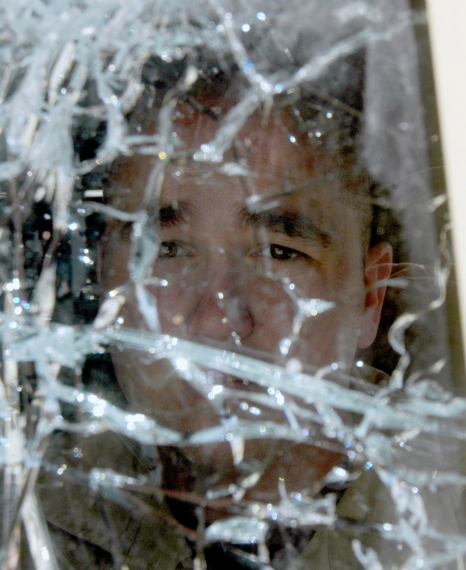 Staff Sgt. Mike Myers peers through the broken windshield of a HUMVEE he drove 15 kilometers after it was hit by a rocket-propelled grenade Sept. 6 in Afghanistan.  The attack came just as his son was born in the U.S.  Sergeant Myers is deployed to the Bagram Provincial Reconstruction Team, Bagram Airfield from Goodfellow Air Force Base, Texas, where he is in the 17th Security Forces Squadron.  He had about three inches of clear glass to look through as he drove the HUMVEE following the attack.  (US Air Force photo/Maj. David Kurle) 