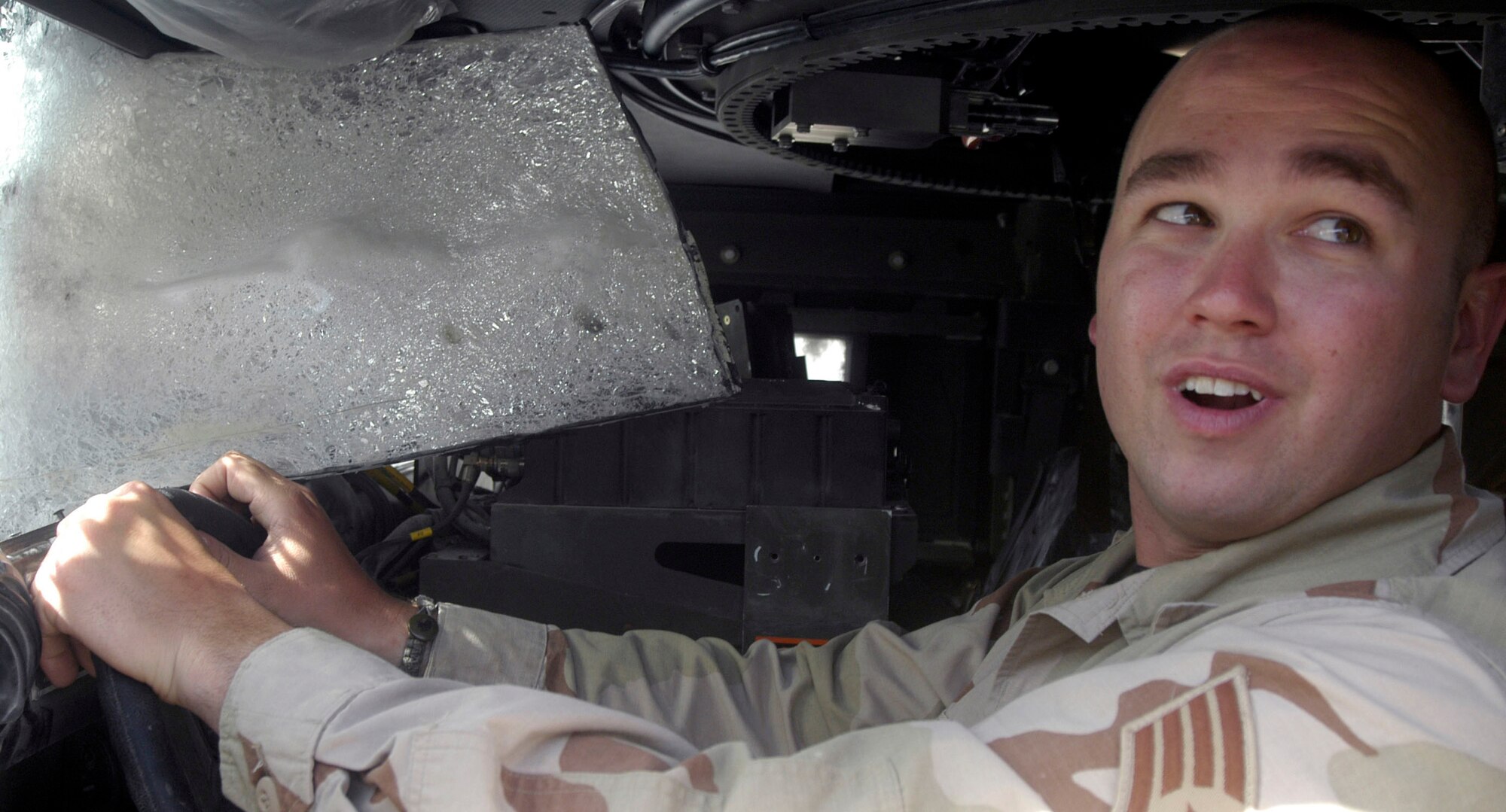 Staff Sergeant Mike Myers explains what happened to an Army motor-pool mechanic at Bagram Airfield, Afghanistan, as he sits in the driver's seat of a HUMVEE he was operating when it was hit by a rocket-propelled grenade. The attack came Sept. 6 at almost the same time his son was being born in the U.S.  Sergeant Myers is a security forces member deployed to the Bagram Provincial Reconstruction Team from Goodfellow Air Force Base, Texas.  (US Air Force photo/Maj. David Kurle)