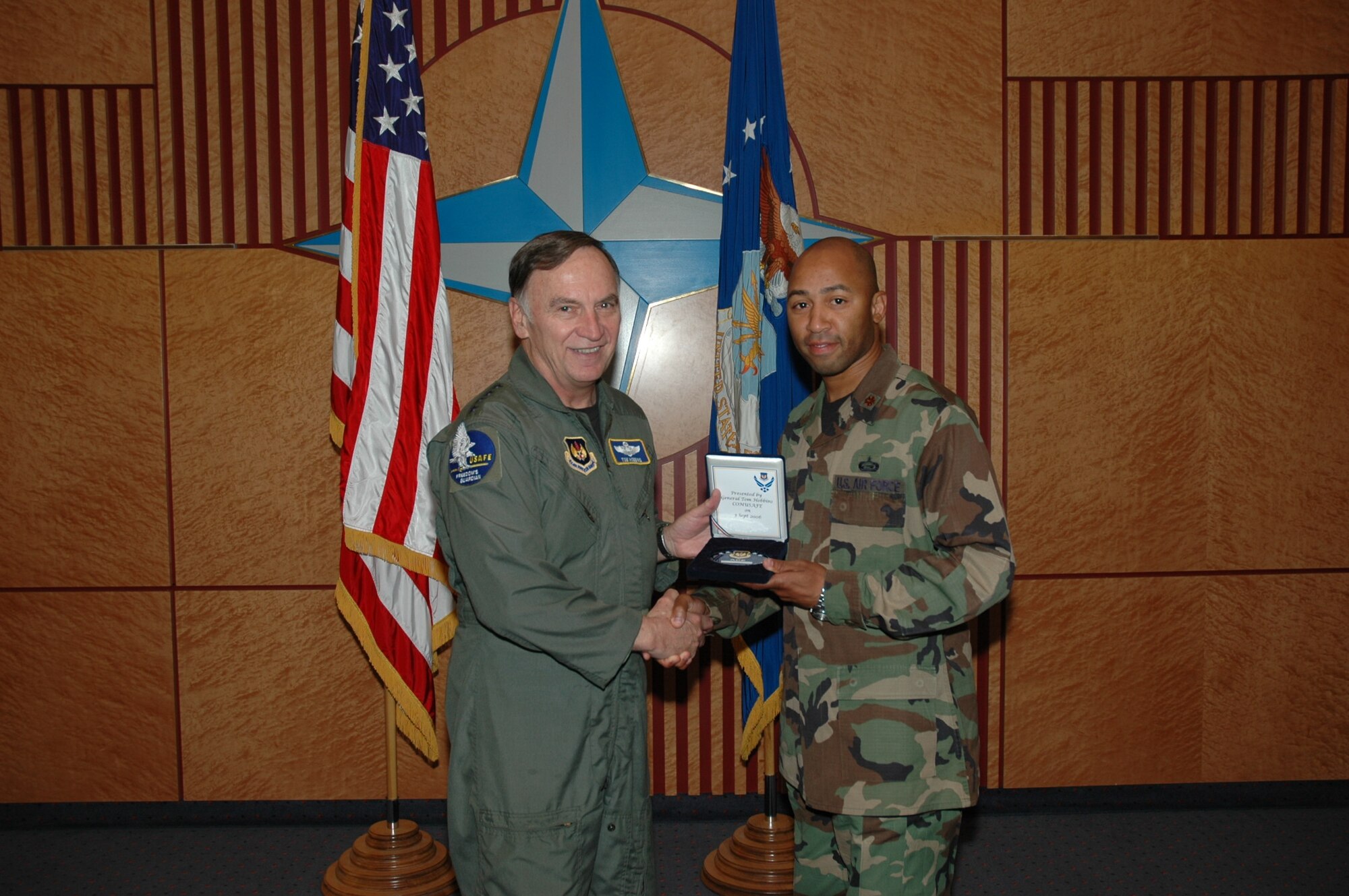 Gen. Tom Hobbins, U.S. Air Forces in Europe commander, (left) presents an ACE coin to Maj. Barnabus Roundtree in recognition of job performance excellence. (U.S. Air Force photo/Master Sgt. Chuck Roberts)