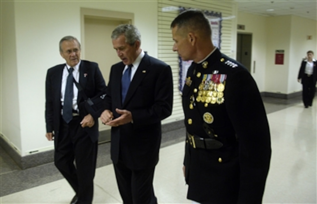 President George W. Bush speaks with Secretary of Defense Donald H. Rumsfeld and Chairman of the Joint Chiefs of Staff Gen. Peter Pace, U.S. Marine Corps, as they walk to a wreath laying ceremony in observance of the fifth anniversary of the Sept.11th terrorist attack at the Pentagon on Sept. 11, 2006.  President and Mrs. Bush will lay a wreath at the crash site of Flight 77 and meet with family members of those who lost their lives at the Pentagon on Sept. 11, 2001. 