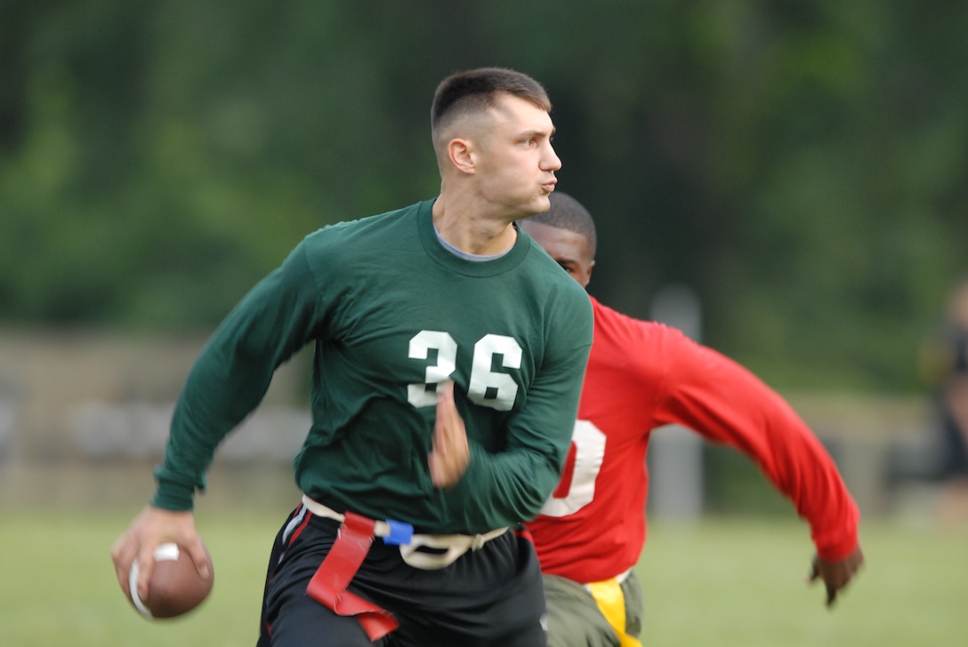 MARINE CORPS BASE CAMP LEJEUNE, N.C. - Lance Cpl. Rodney Adams, quarterback for 2nd Tank Battalion, evades Cpl. Chad Boudrauex with 8th Communications Battalion as he scans for an open receiver here Sept. 11. Communication Battalion defeated Tank Battalion 13-12 in one of the first games of the 2006 Intramural Flag Football game.