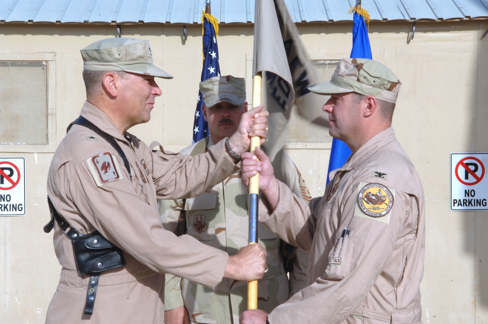 Brig. Gen. Christopher Miller, 455th Air Expeditionary Wing commander passes the guidon to Col. Hank Santicola, the new 455th Expeditionary Operations Group commander during a change of command ceremony here Sept. 14.  Col. Santicola is an A-10 pilot and is deployed from the 23rd Fighter Group "Flying Tigers" at Pope Air Force Base, N.C. (U.S. Air Force photo/Tech. Sgt. Joseph Kapinos)