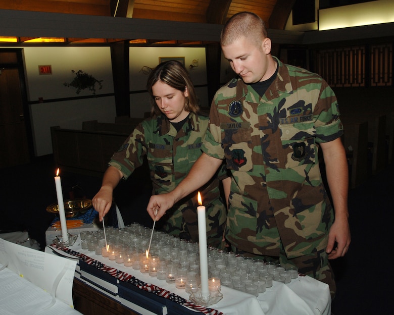 MINOT AIR FORCE BASE, N.D. -- Airman 1st Class Tiffany Talyor, 5th Bomb Wing and A 1st Class Jeremy Taylor, 5th Maintenance Squadron,  light candles at the Northern Plains chapel here on the five year anniversary of  September 11, 2001.  (U.S. Air Force photo by Airman 1st Class Cassandra Butler)