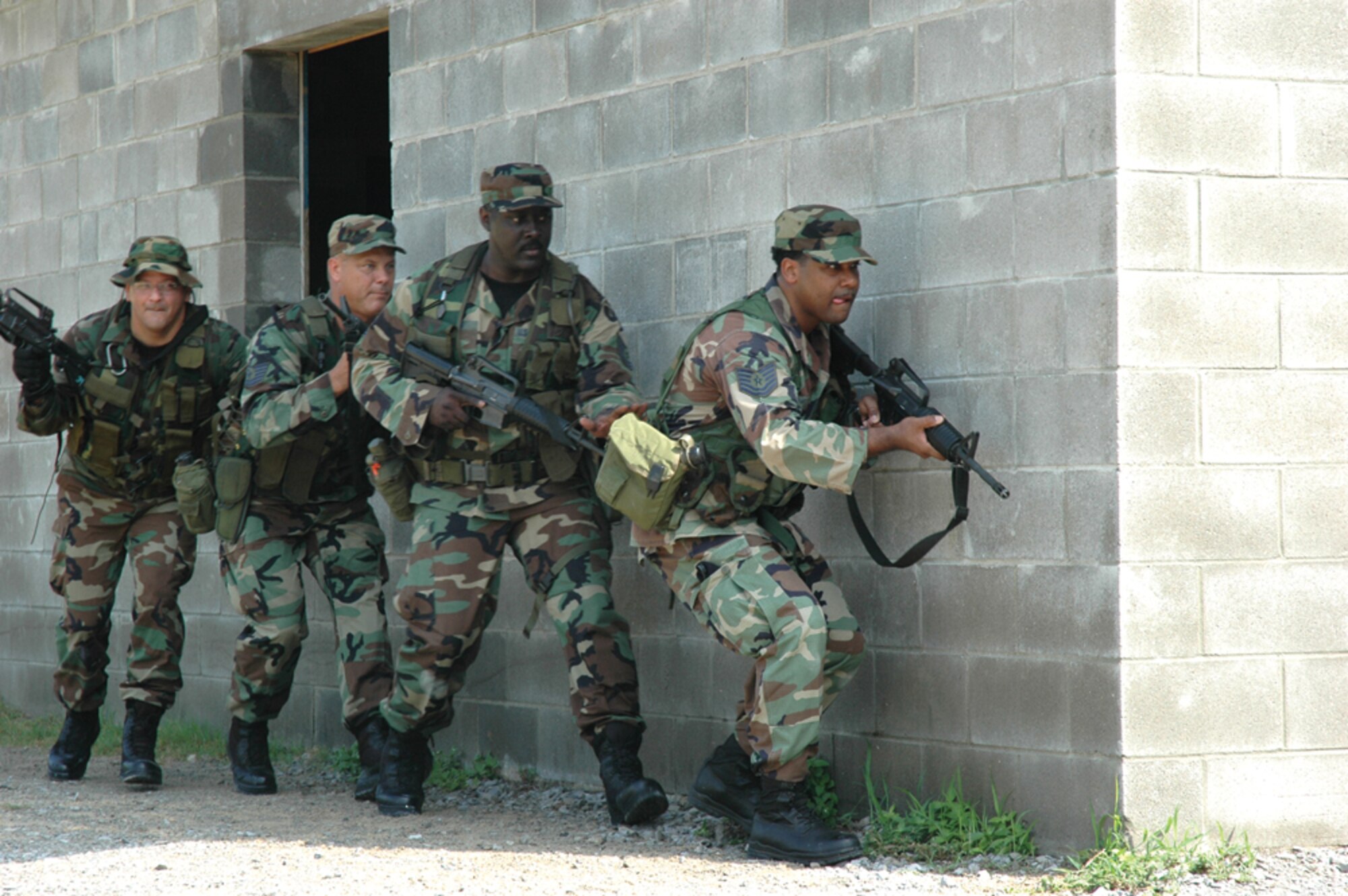 (Left to right) Tech. Sgts. Larry Smith, Willie Givens, and Darrell Womack, 919th Security Forces Squadron fire team members, scan their surroundings during Military Operations in Urban Terrain training Aug. 5 at Eglin Air Force Base.