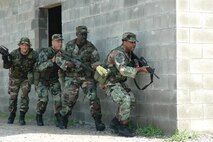 (Left to right) Tech. Sgts. Larry Smith, Willie Givens, and Darrell Womack, 919th Security Forces Squadron fire team members, scan their surroundings during Military Operations in Urban Terrain training Aug. 5 at Eglin Air Force Base.