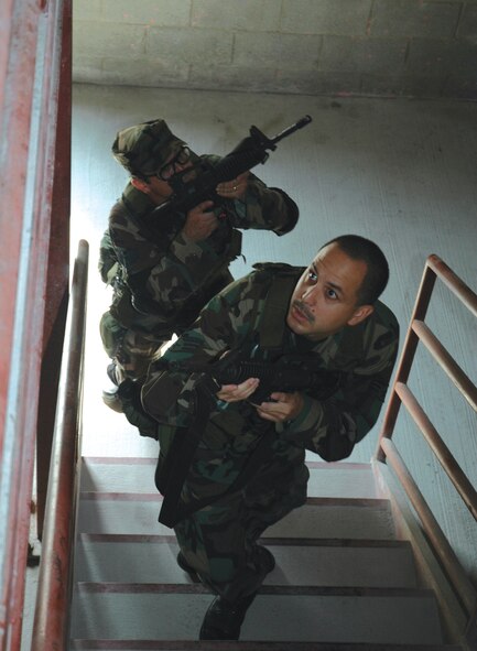 Senior Airman Arturo Rios Jr. (front) and David Johnson, 919th SFS fire team members, advance and clear a stairwell in search of insurgents. MOUT training builds situational awareness and specific attention to detail.